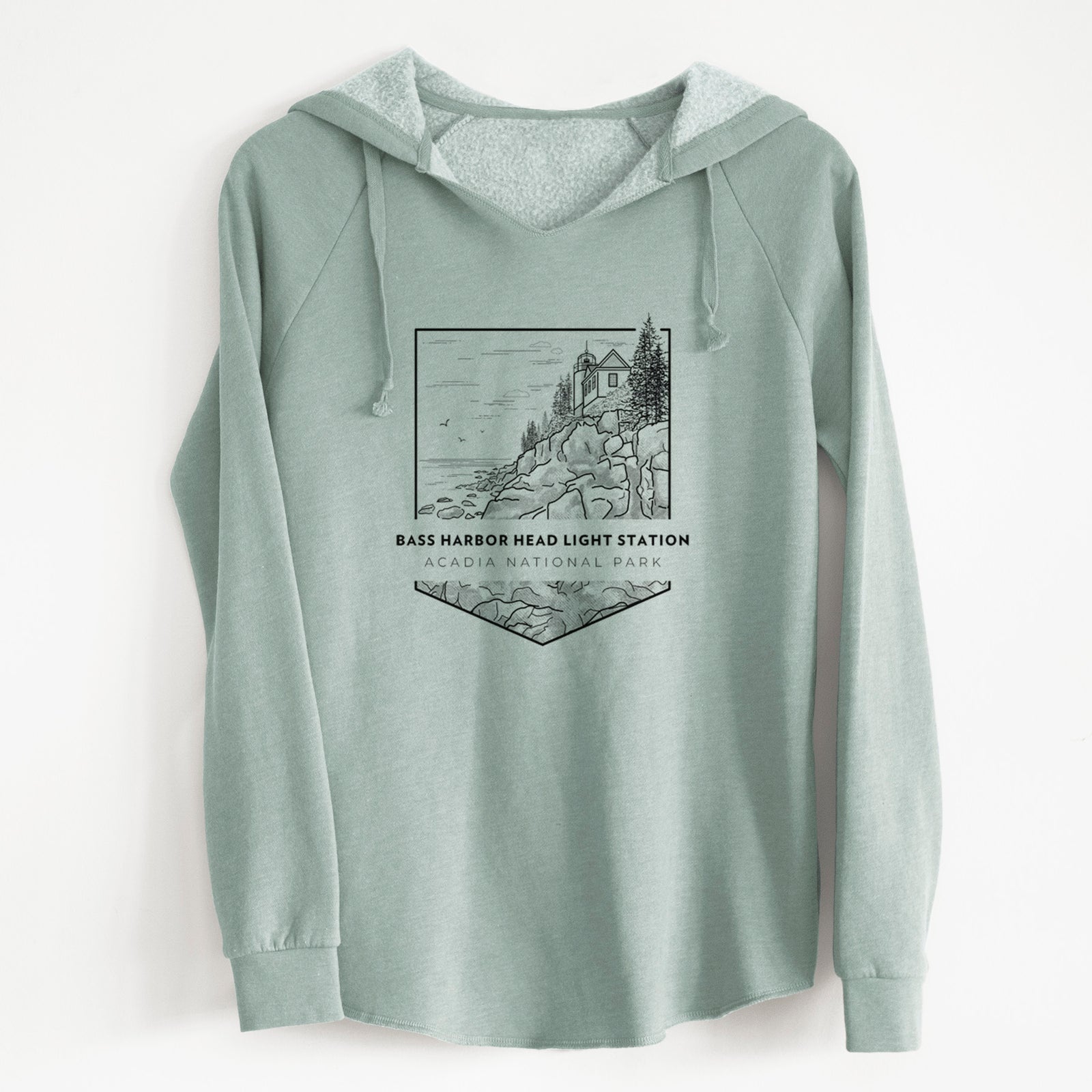 Sage green women's Cali Wave hooded sweatshirt laid flat, printed with a black line art badge of Bass Harbor Head Light Station on a rocky cliff, with the words Acadia National Park.