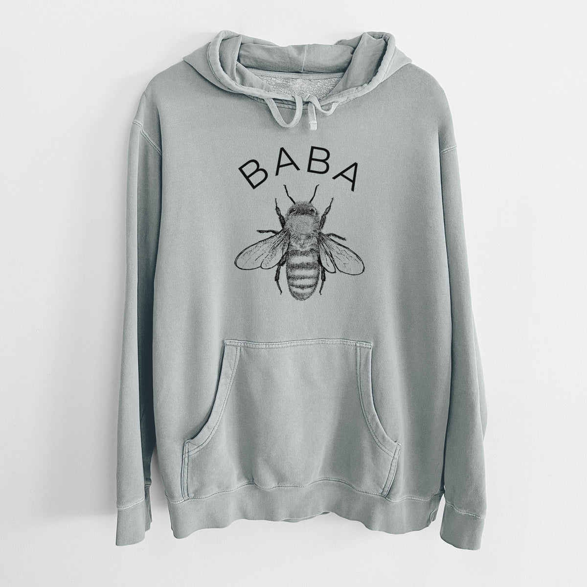Sage green pigment dyed hoodie laid flat, printed with a black ink honey bee beneath the word Baba.