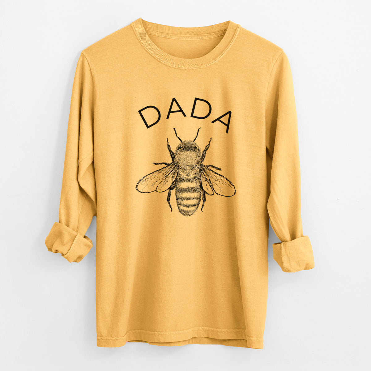 Golden wheat yellow Comfort Colors long sleeve shirt laid flat with the cuffs rolled, printed with a black ink honey bee beneath the word Dada.