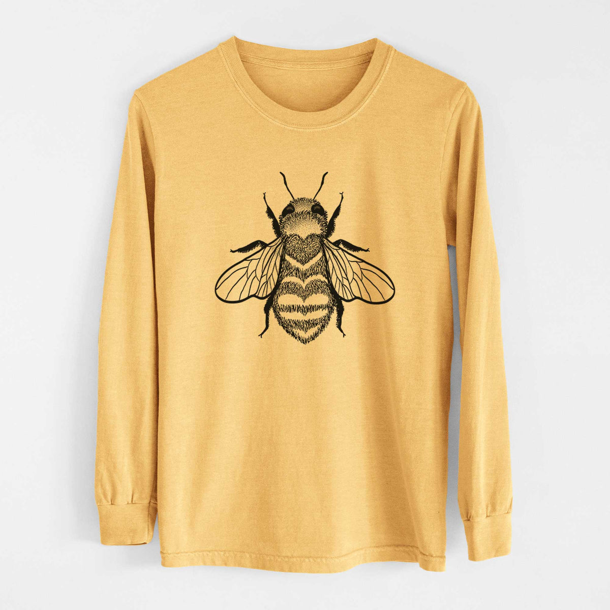 Golden wheat yellow Comfort Colors long sleeve shirt laid flat, printed with a black ink bee with a heart pattern on its body.