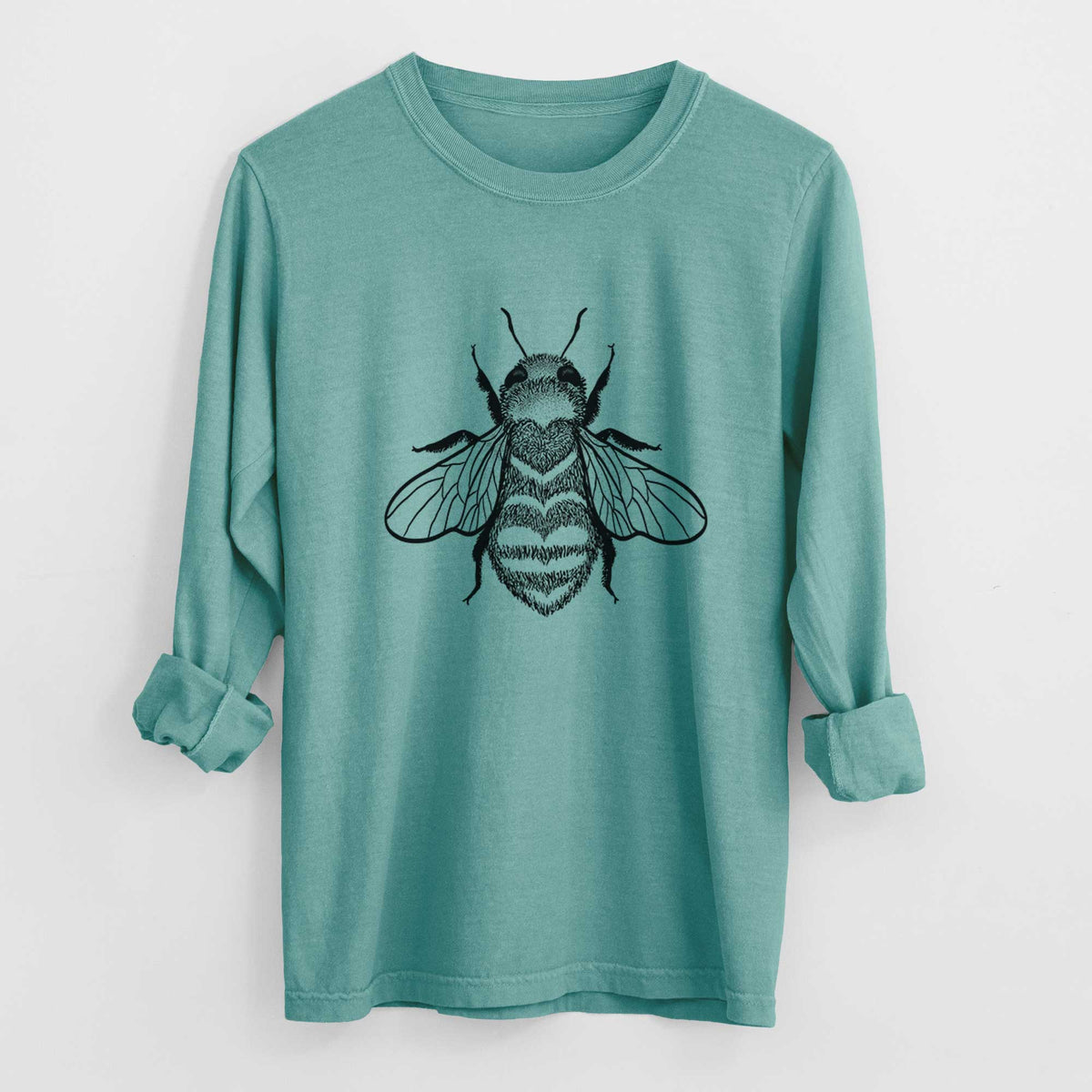 Reef green Comfort Colors long sleeve shirt laid flat with the cuffs rolled, printed with a black ink bee with a heart pattern on its body.