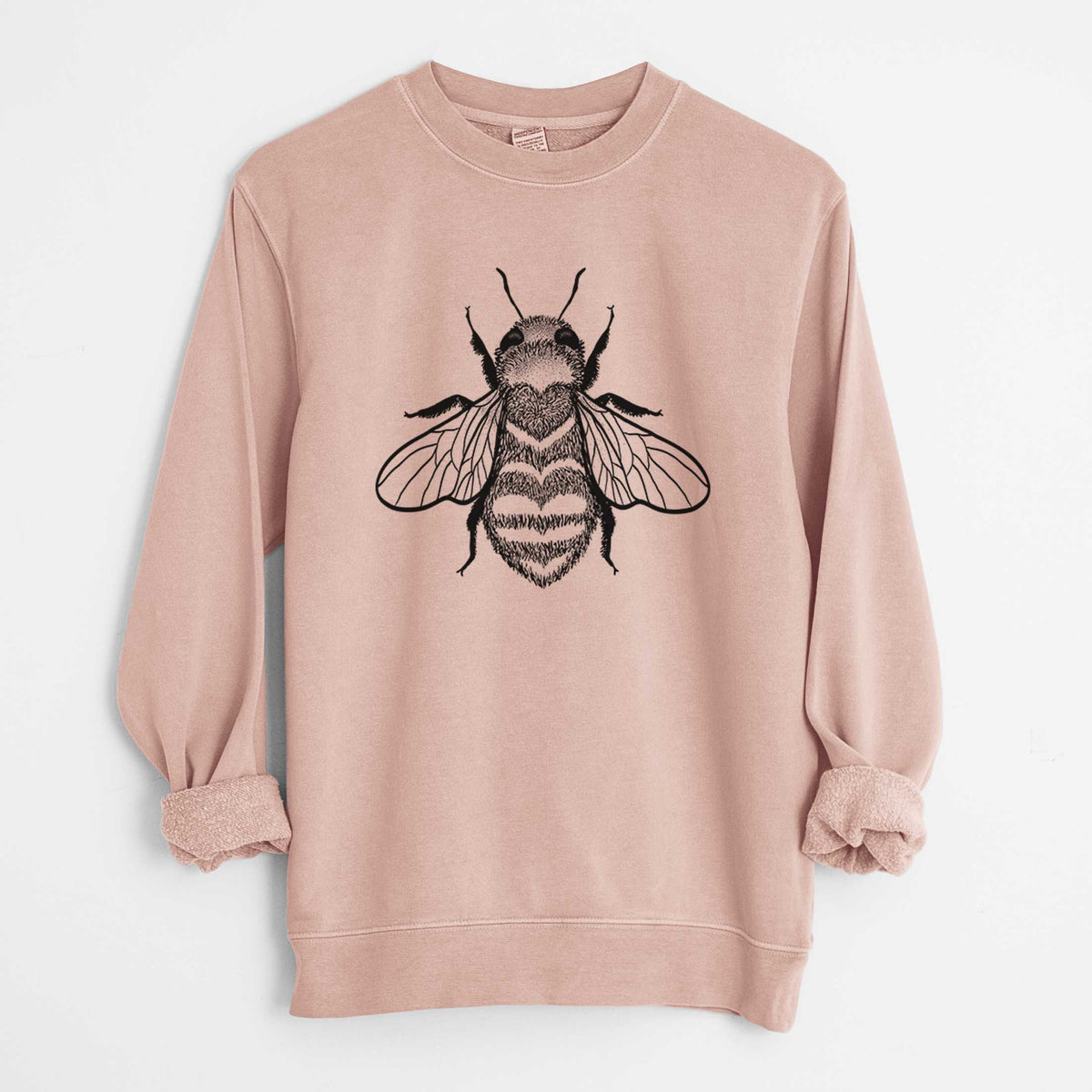 Dusty pink pigment dyed crewneck sweatshirt laid flat with the sleeves rolled, printed with a black ink bee with a heart pattern on its body.