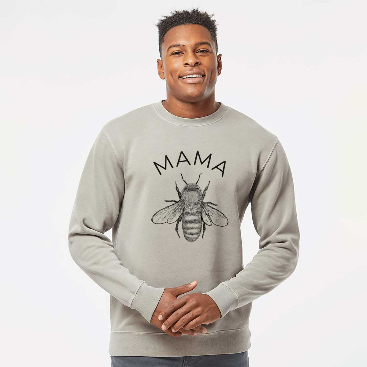 Model wearing a cement grey pigment dyed crewneck sweatshirt printed with a black ink honey bee beneath the word Mama.