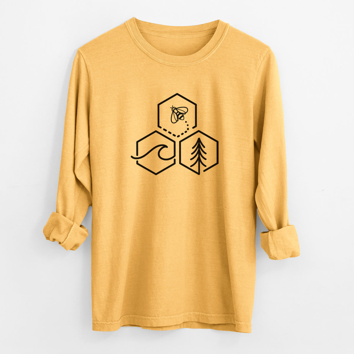 Golden wheat yellow Comfort Colors long sleeve shirt laid flat with the cuffs rolled, printed with a black line art design of three hexagons holding a bee, an ocean wave and a pine tree.