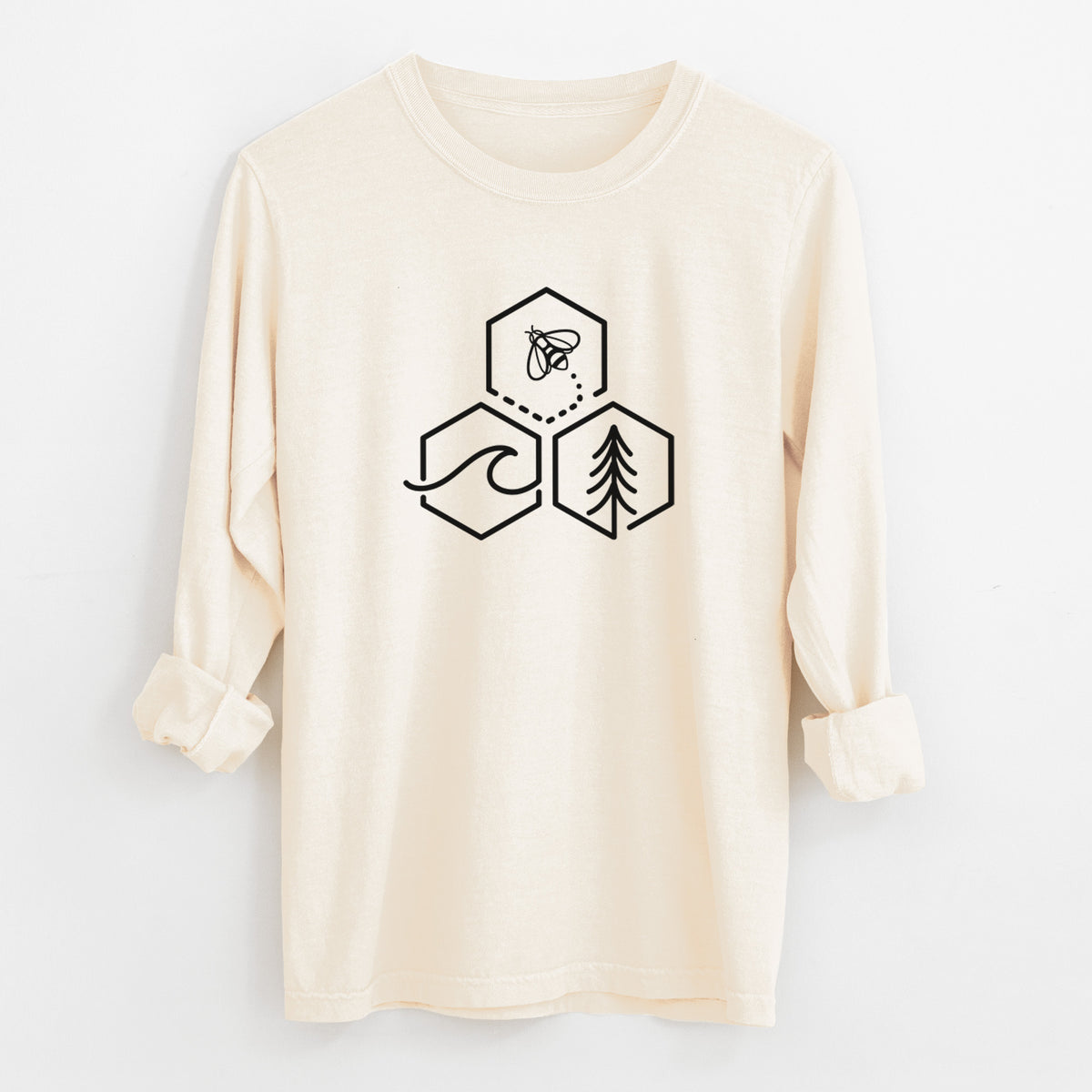 Ivory Comfort Colors long sleeve shirt laid flat with the cuffs rolled, printed with a black line art design of three hexagons holding a bee, an ocean wave and a pine tree.