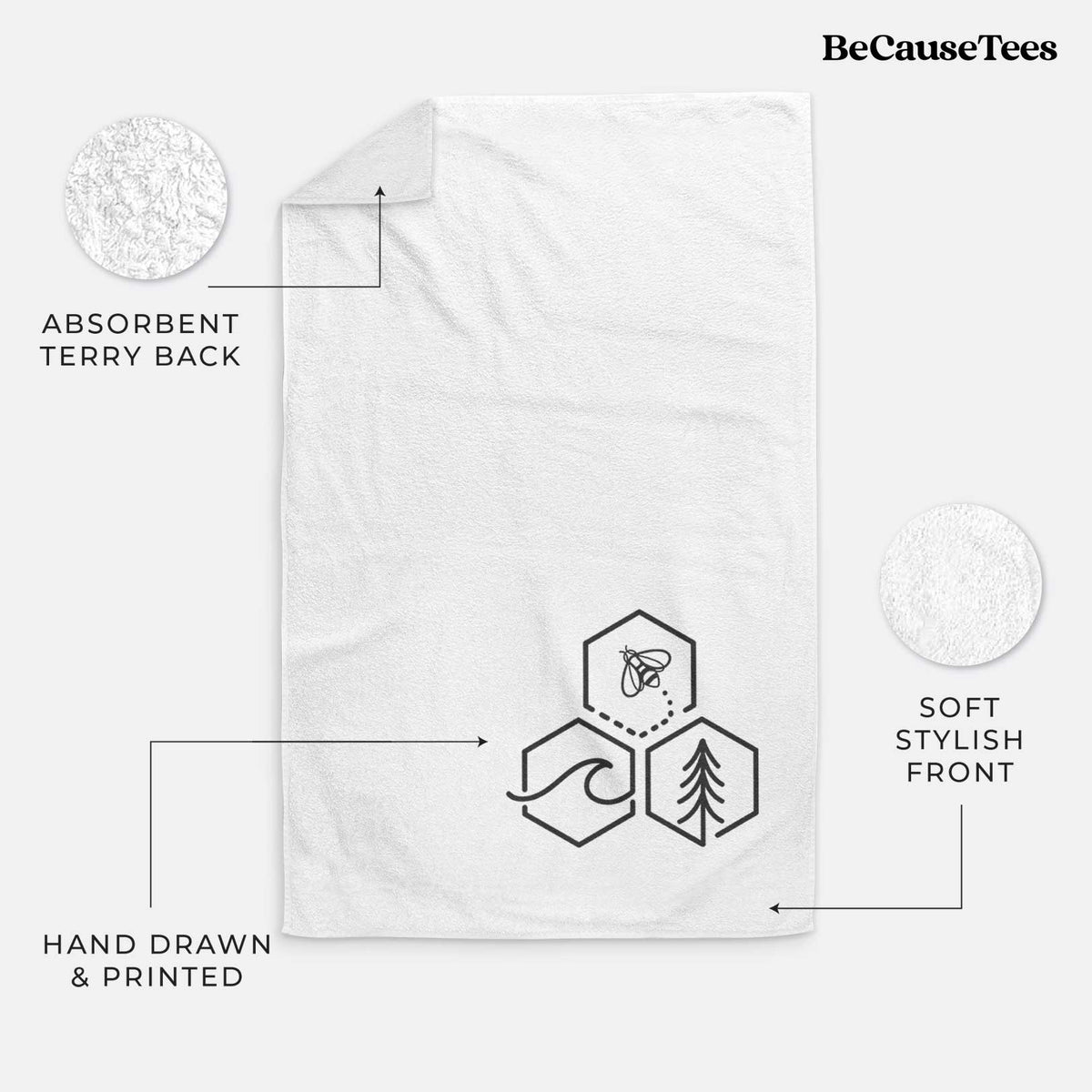 White hand towel printed with a black line art design of three hexagons holding a bee, an ocean wave and a pine tree.