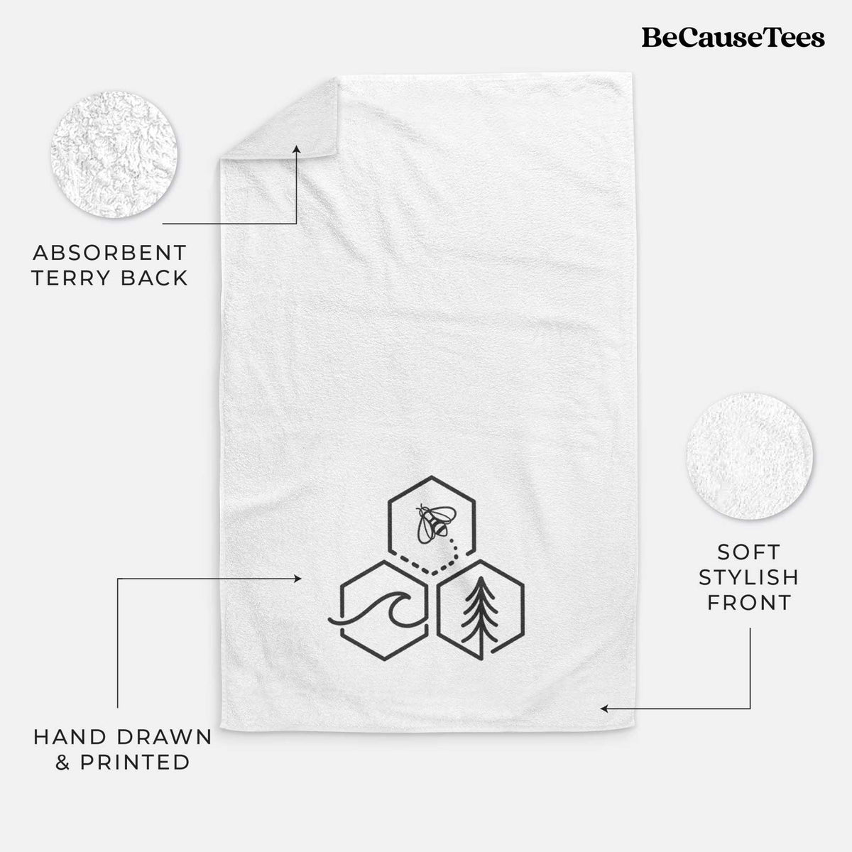 White hand towel printed with a black line art design of three hexagons holding a bee, an ocean wave and a pine tree.