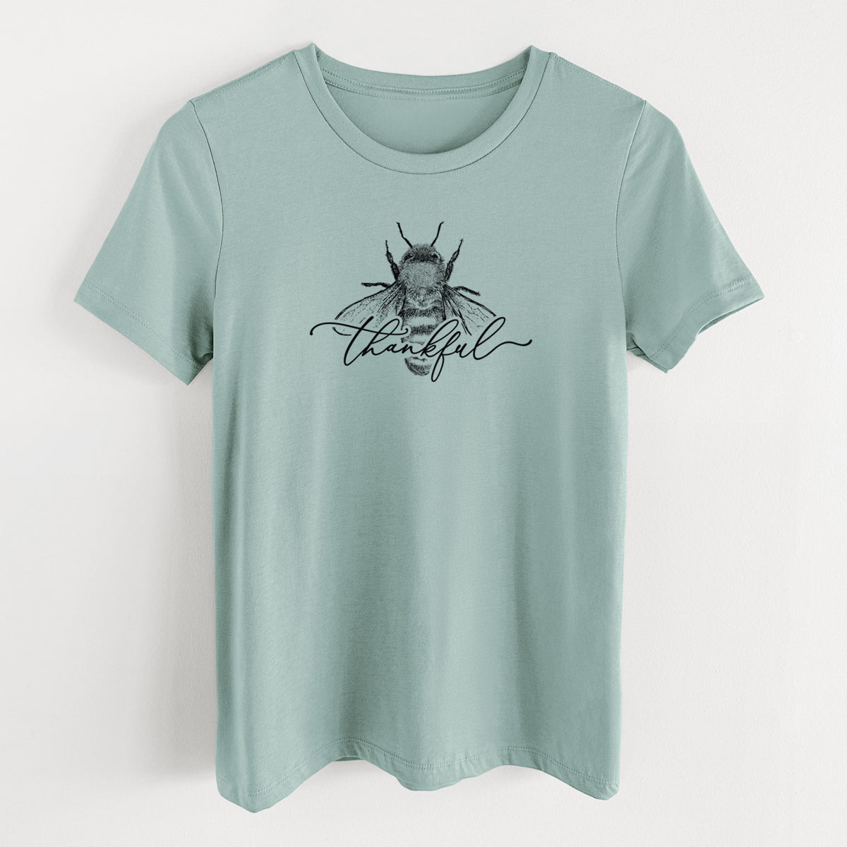Dusty blue women's relaxed fit cotton t-shirt laid flat, printed with a black ink bee with the word thankful written in script across it.