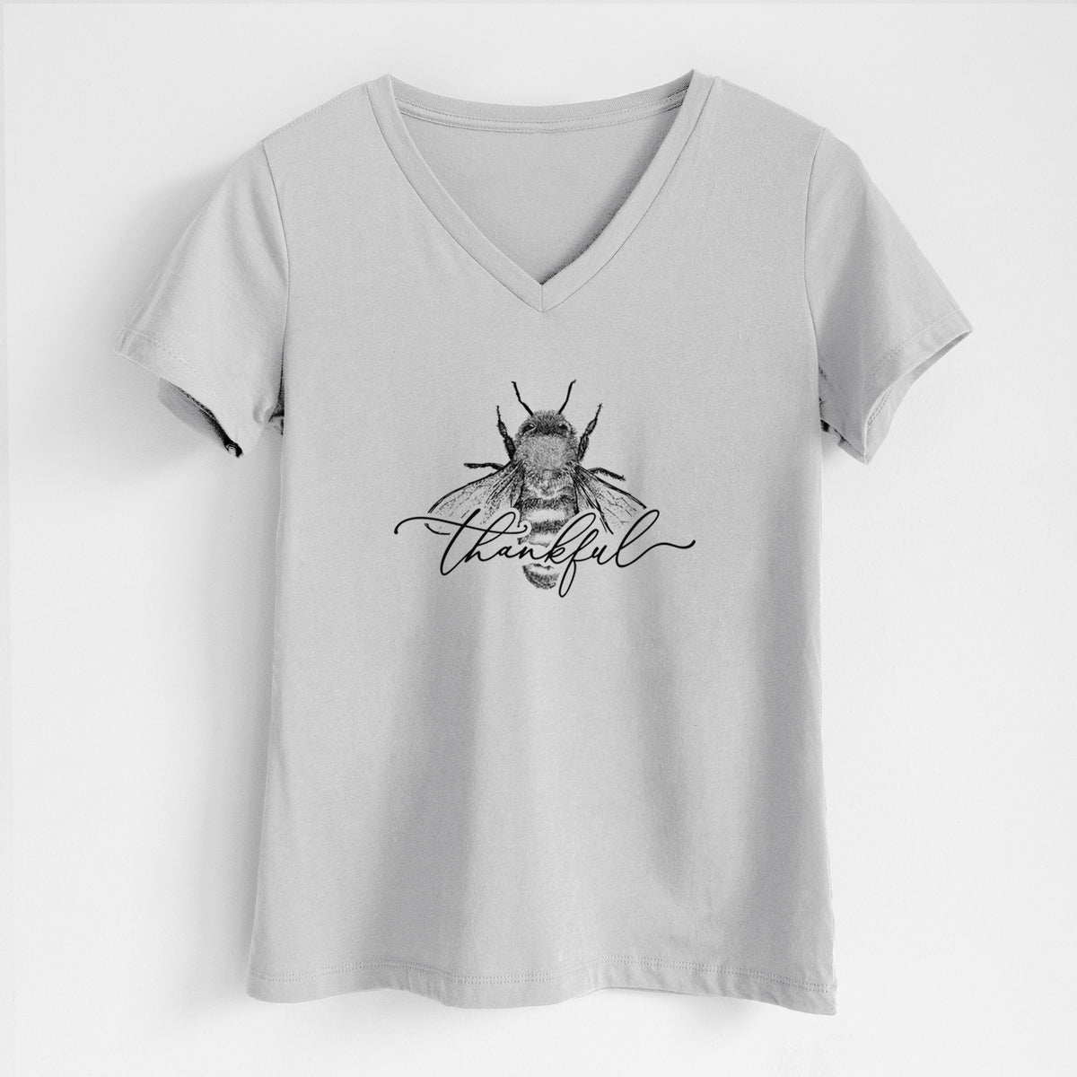 Lunar grey women's relaxed fit cotton V-neck t-shirt laid flat, printed with a black ink bee with the word thankful written in script across it.