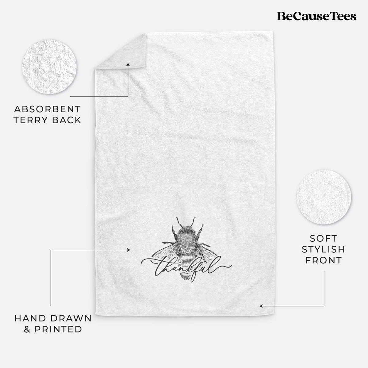White hand towel printed with a black ink bee with the word thankful written in script across it.