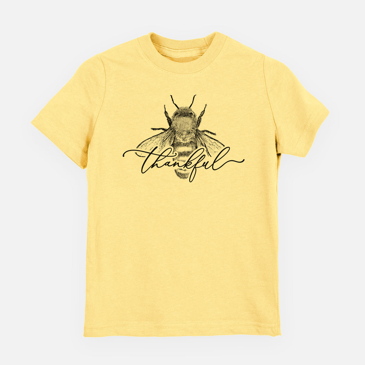 Butter yellow youth t-shirt laid flat, printed with a black ink bee with the word thankful written in script across it.