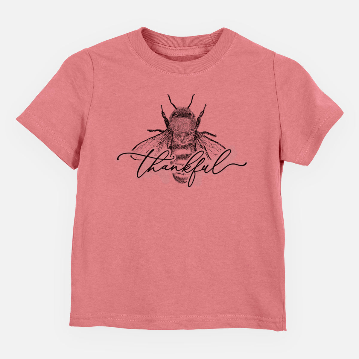 Mauve pink toddler t-shirt laid flat, printed with a black ink bee with the word thankful written in script across it.