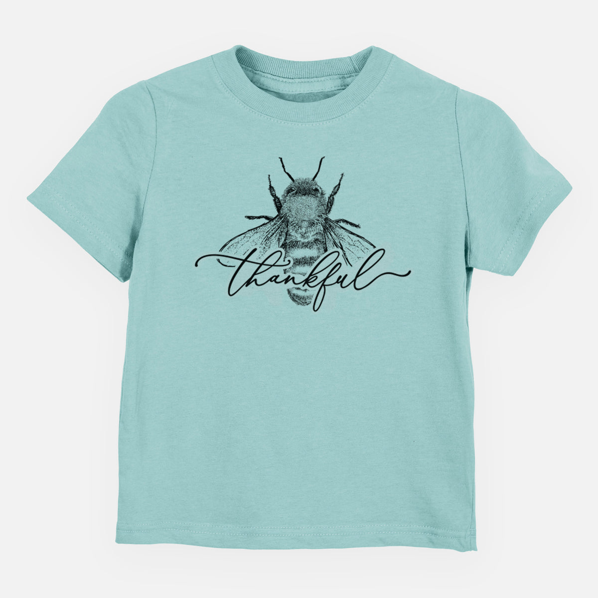 Saltwater toddler t-shirt laid flat, printed with a black ink bee with the word thankful written in script across it.