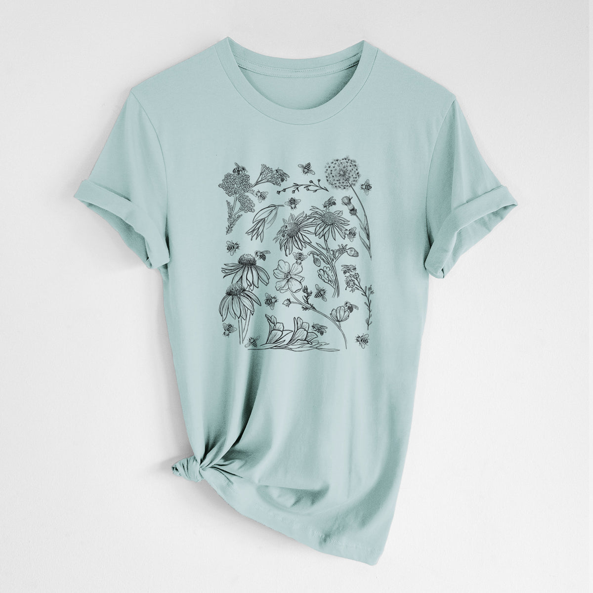 Dusty blue lightweight cotton t-shirt laid flat with the sleeves rolled, printed with black ink bees scattered among wildflowers.