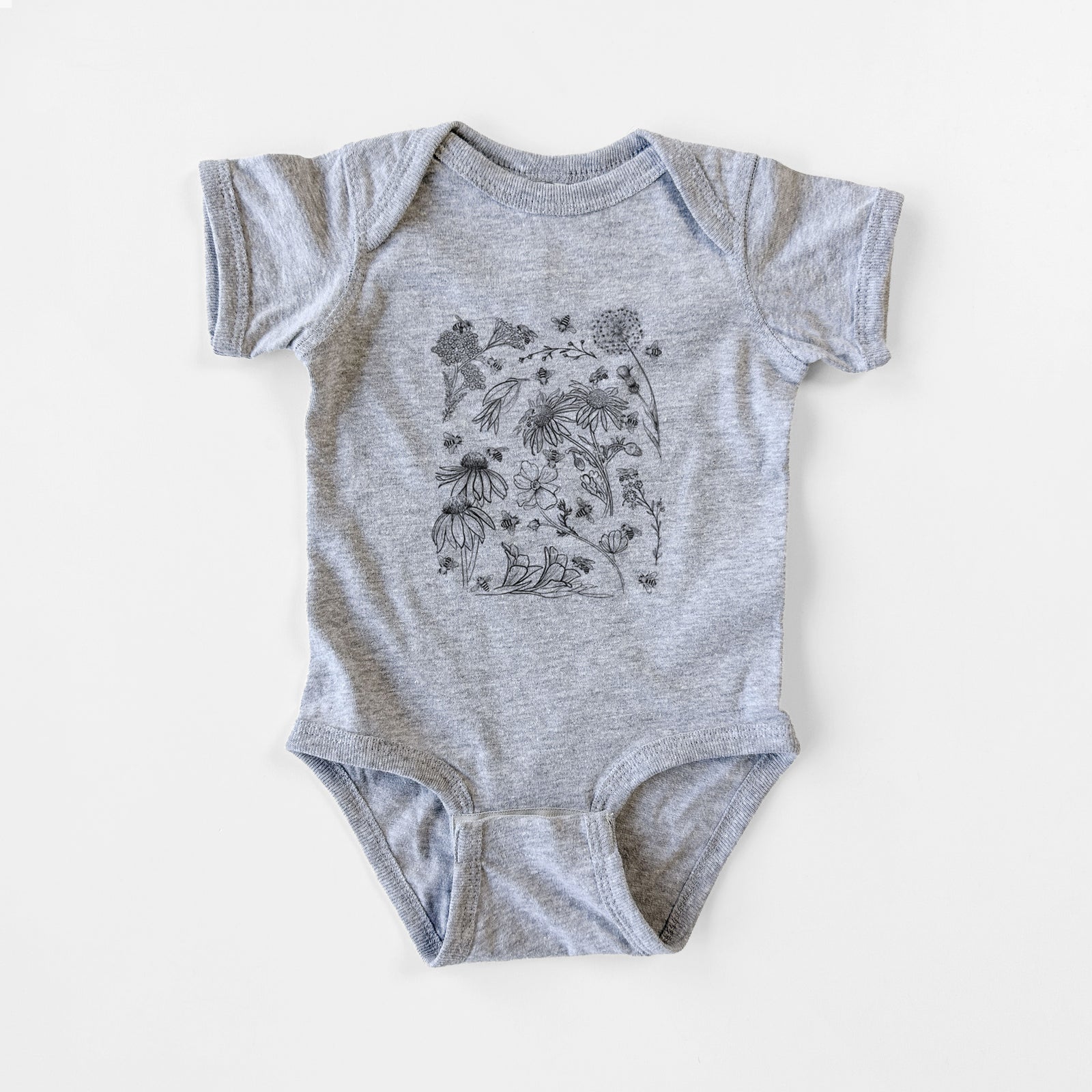 Grey baby bodysuit laid flat, printed with black ink bees scattered among wildflowers.