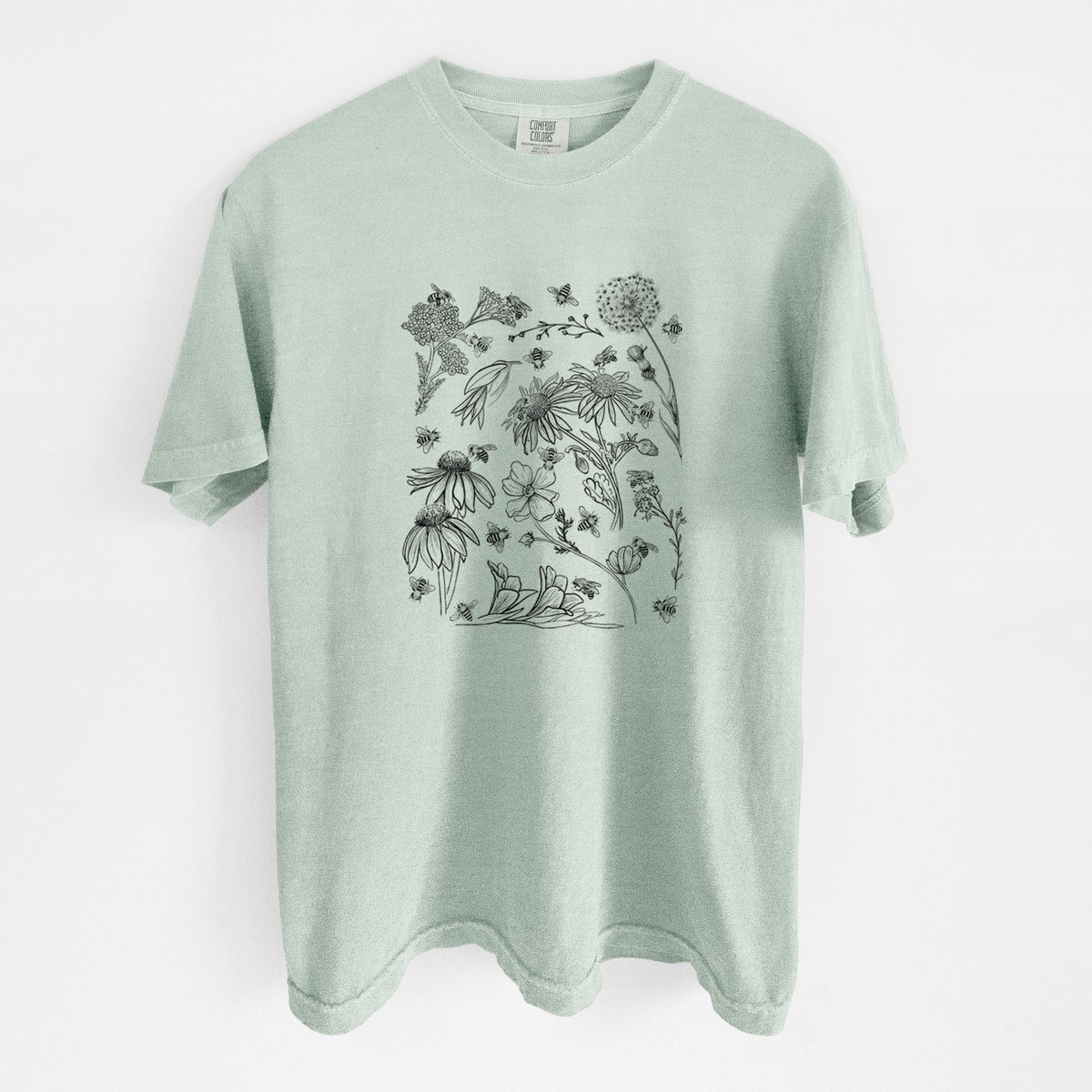 Bay green Comfort Colors t-shirt laid flat, printed with black ink bees scattered among wildflowers.
