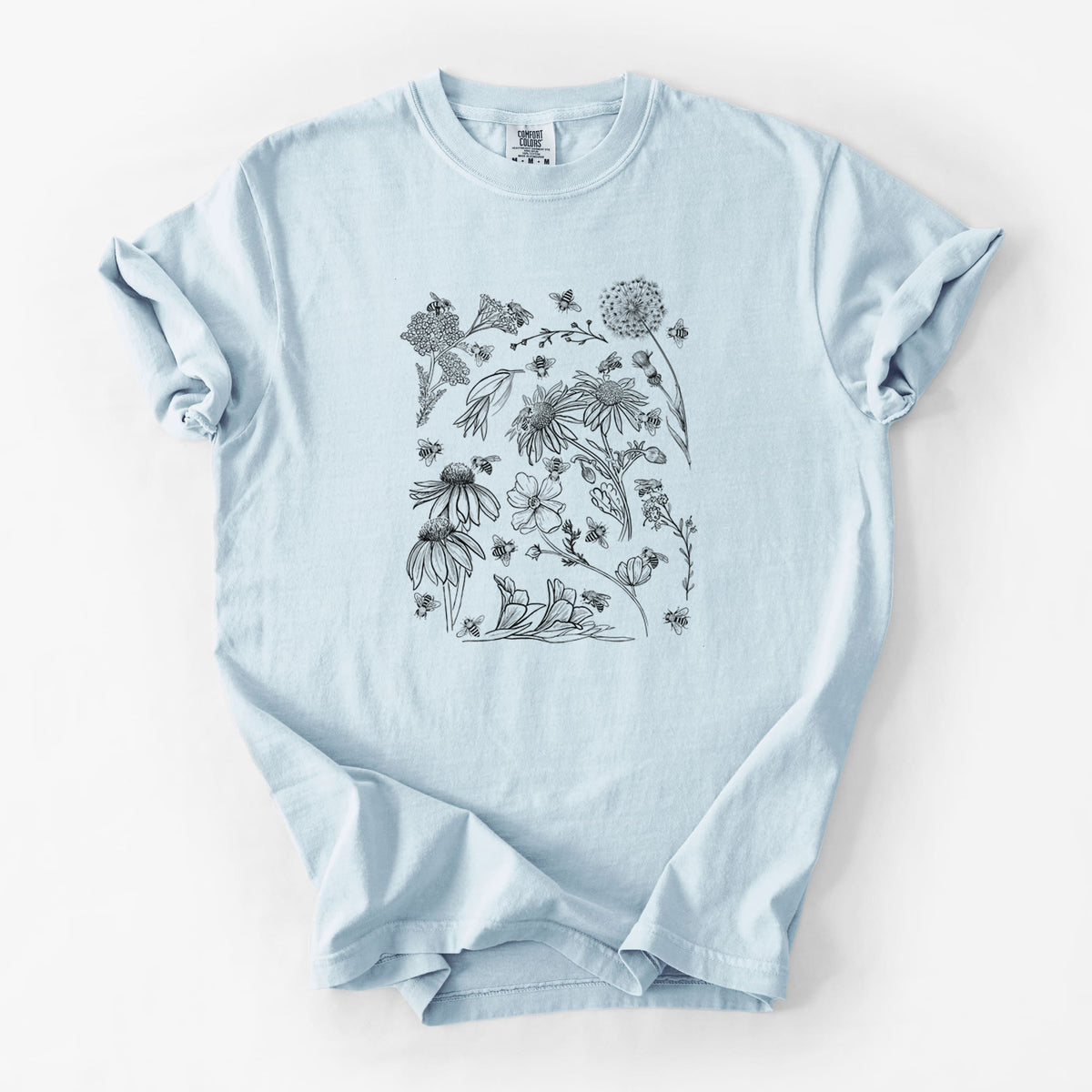 Chambray blue Comfort Colors t-shirt laid flat, printed with black ink bees scattered among wildflowers.
