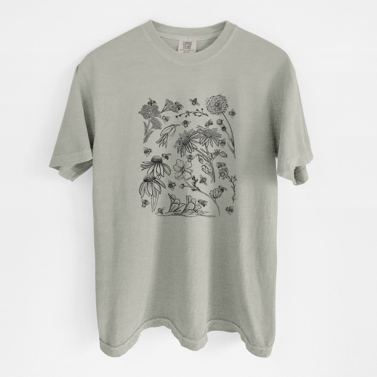 Sandstone beige Comfort Colors t-shirt laid flat, printed with black ink bees scattered among wildflowers.