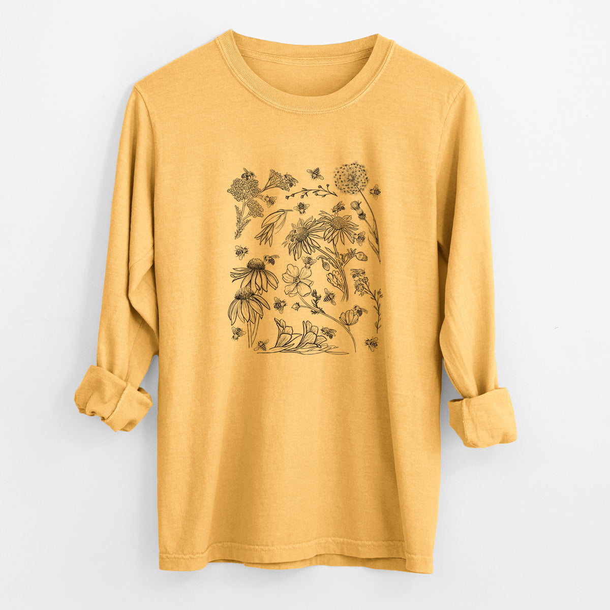 Golden wheat yellow Comfort Colors long sleeve shirt laid flat with the cuffs rolled, printed with black ink bees scattered among wildflowers.
