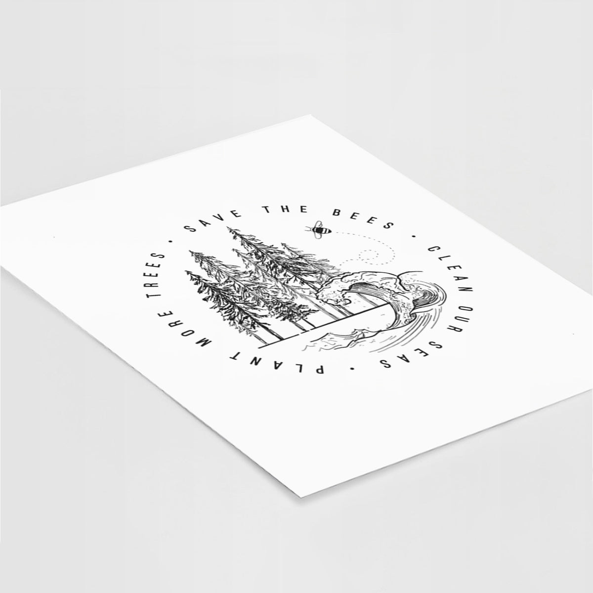 Art print of a circle of pine trees and an ocean wave ringed by the words Save the Bees, Clean Our Seas, Plant More Trees, lying at an angle on a white surface.