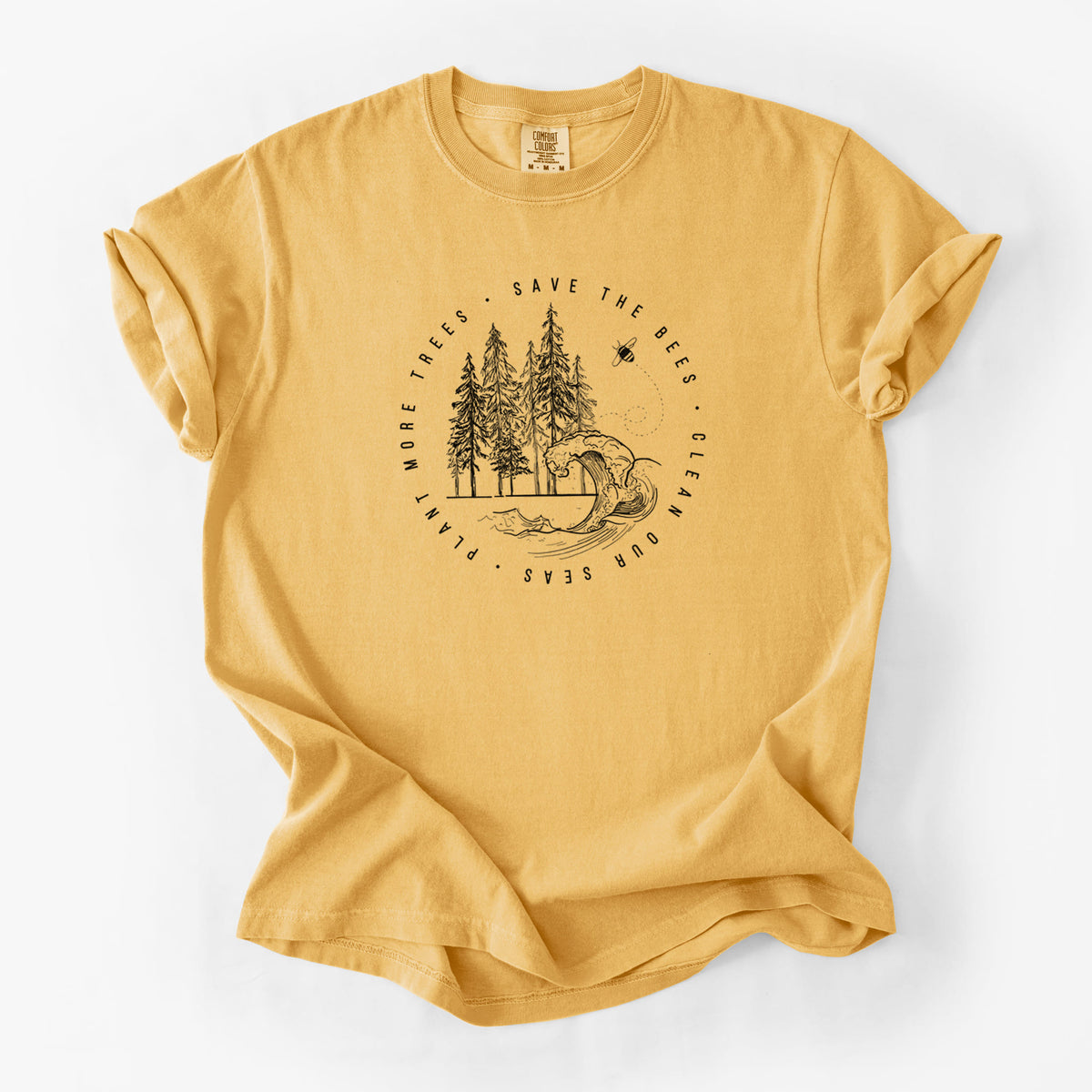 Golden wheat yellow Comfort Colors t-shirt laid flat, printed with a circle of pine trees and an ocean wave ringed by the words Save the Bees, Clean Our Seas, Plant More Trees.