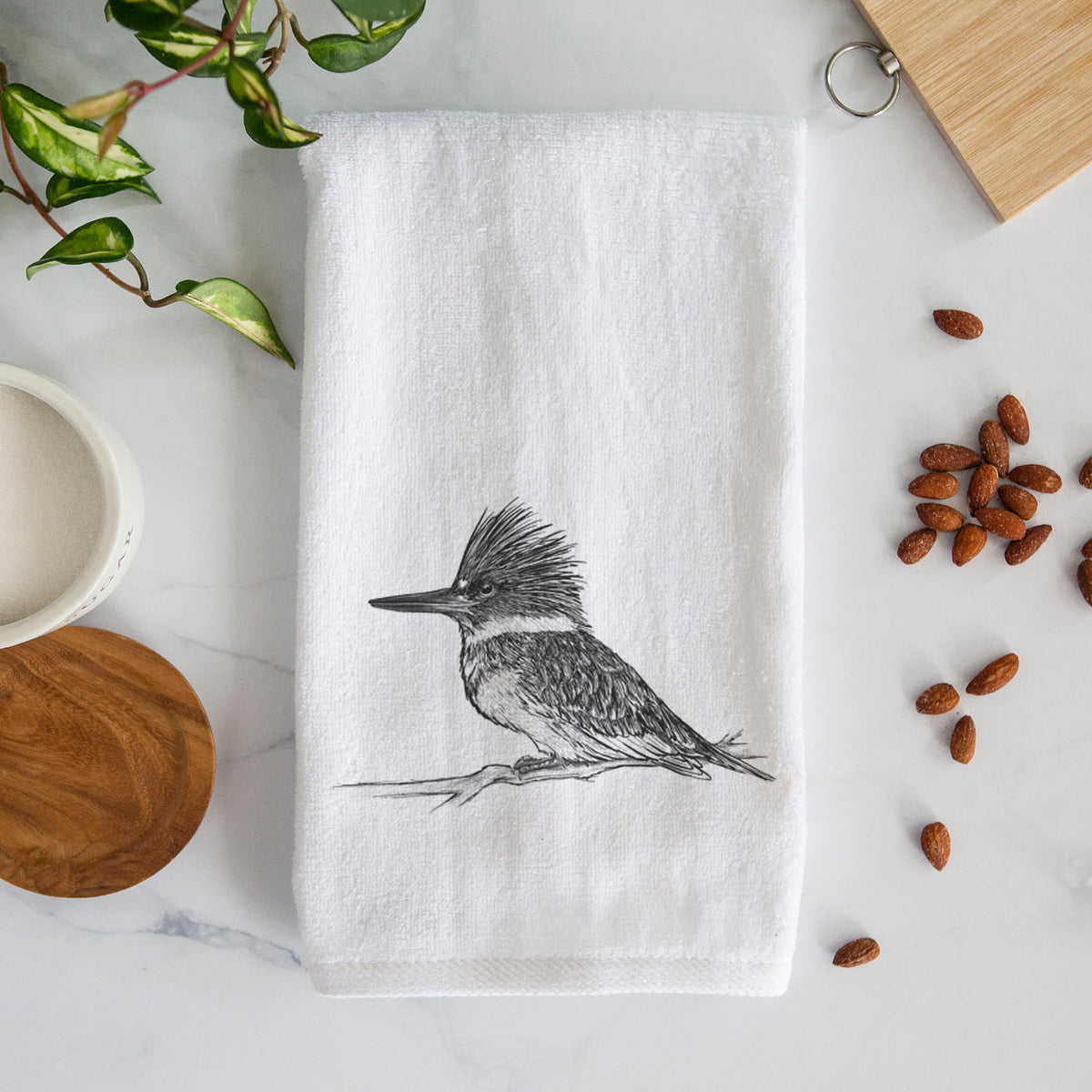 White hand towel printed with a detailed black ink sketch of a belted kingfisher perched on a branch.