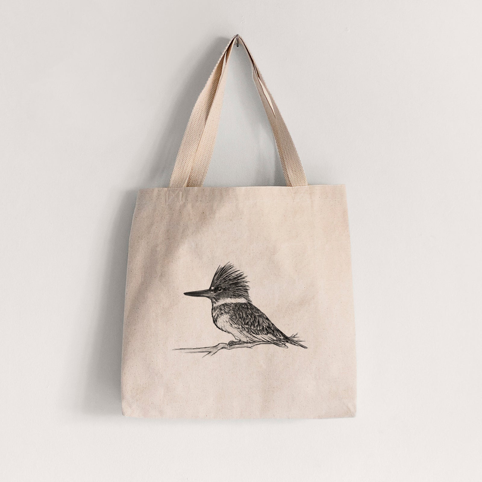 Natural canvas tote bag printed with a detailed black ink sketch of a belted kingfisher perched on a branch.