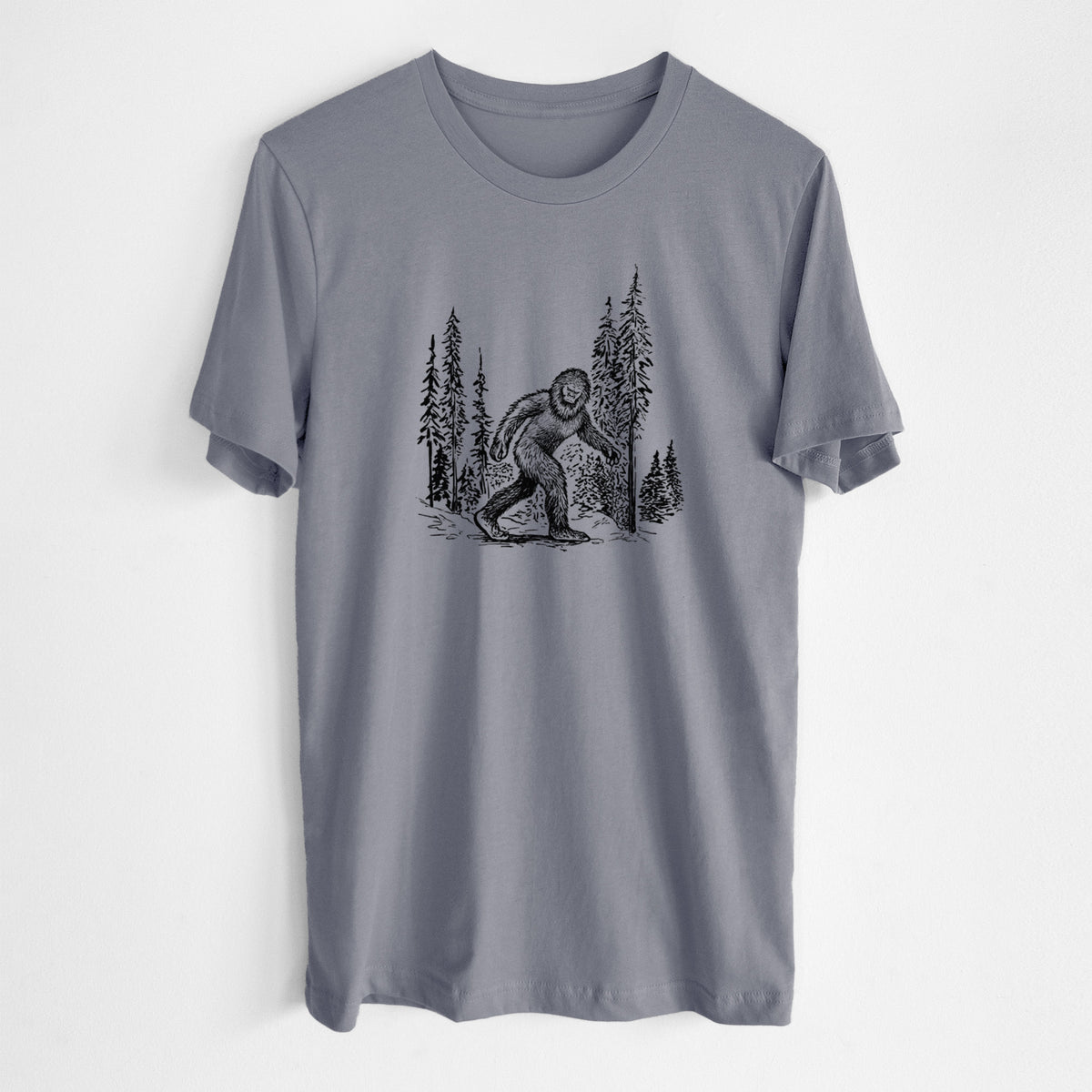 Storm grey lightweight cotton t-shirt laid flat, printed with a black ink illustration of Bigfoot walking through a pine forest.
