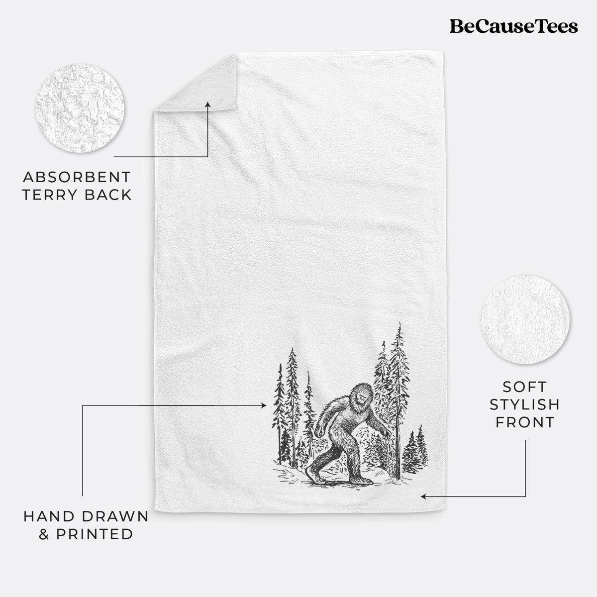 White hand towel printed with a black ink illustration of Bigfoot walking through a pine forest.