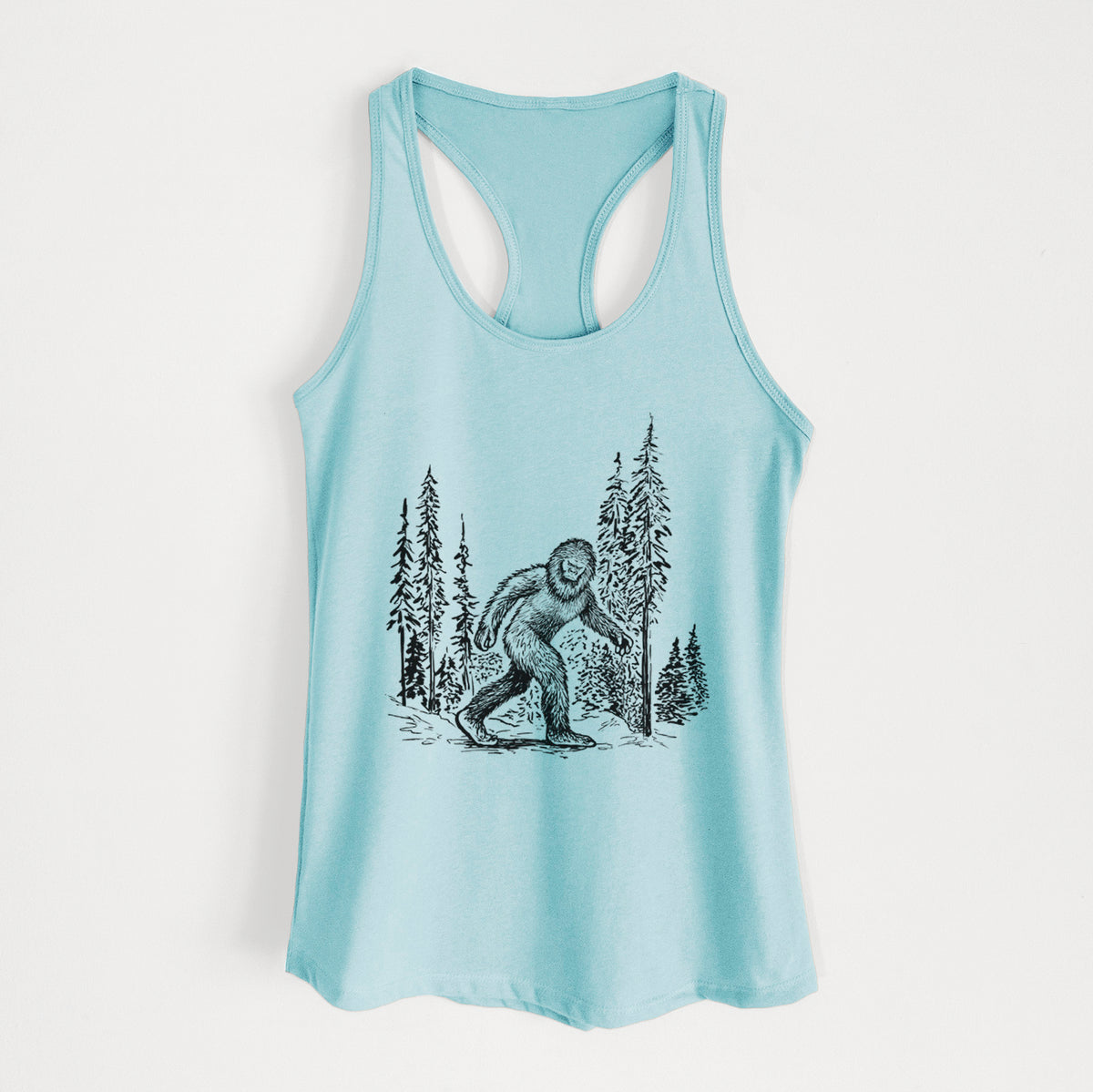 Cancun blue women's racerback tank top laid flat, printed with a black ink illustration of Bigfoot walking through a pine forest.