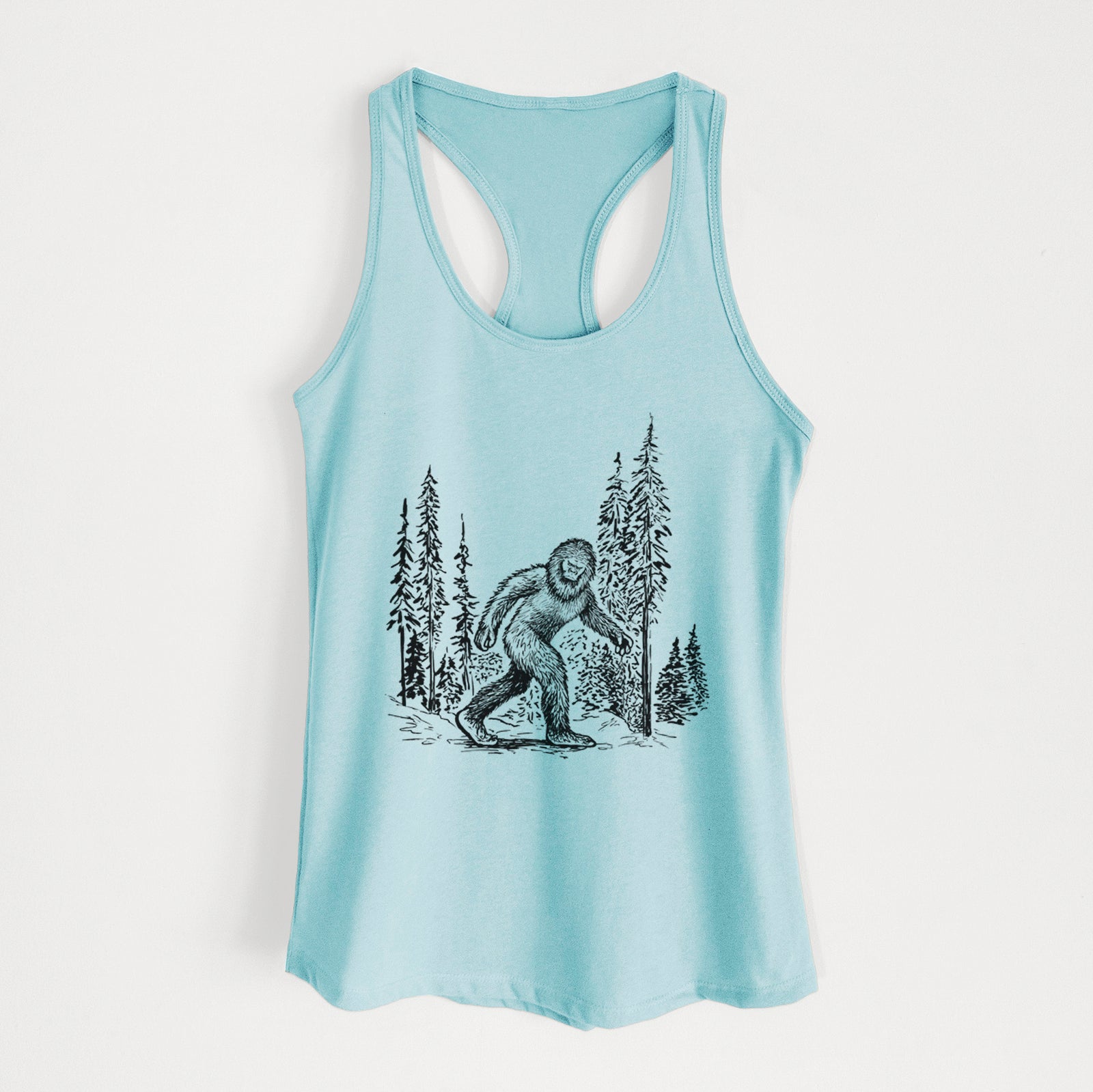 Banana cream women's racerback tank top laid flat, printed with a black ink illustration of Bigfoot walking through a pine forest.