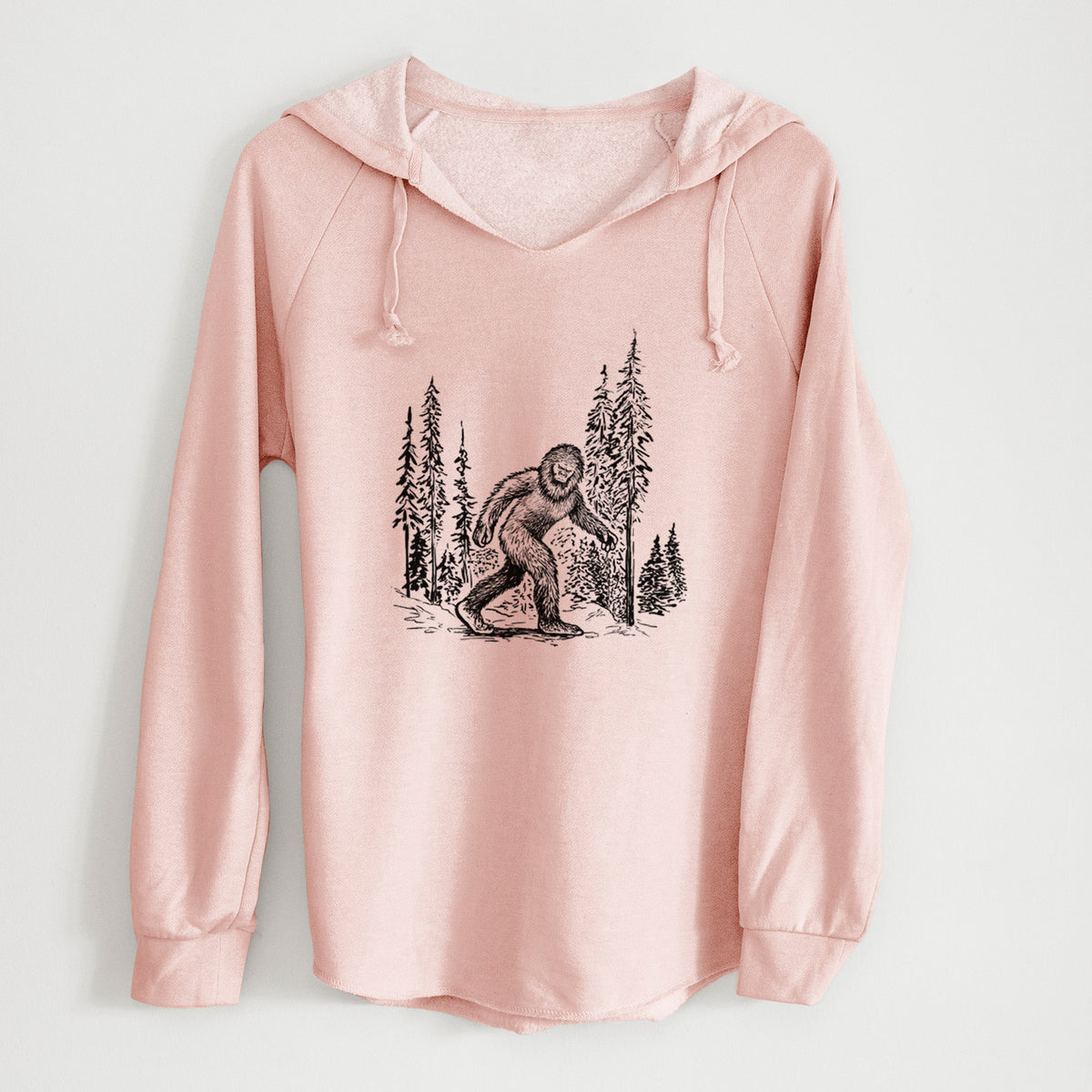 Blush pink women's Cali Wave hooded sweatshirt laid flat, printed with a black ink illustration of Bigfoot walking through a pine forest.