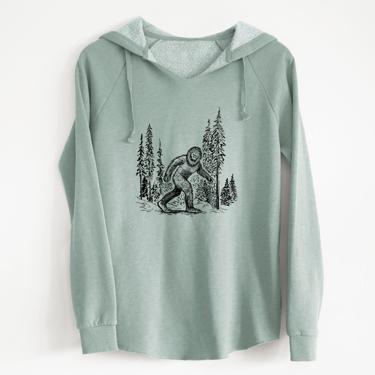 Sage green women's Cali Wave hooded sweatshirt laid flat, printed with a black ink illustration of Bigfoot walking through a pine forest.