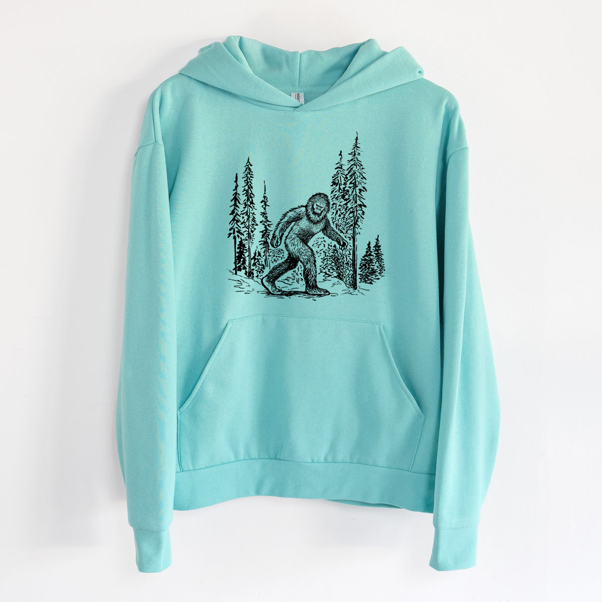 Bigfoot in the Woods - Statement Midweight Hoodie in Seafoam, hanging on a white wall, with a front kangaroo pocket and no drawcords.