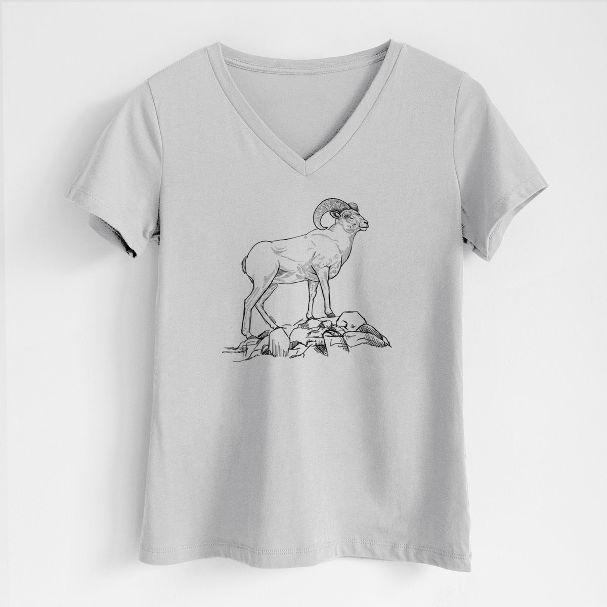 Lunar grey women's relaxed fit cotton V-neck t-shirt laid flat, printed with a black ink illustration of a bighorn ram with curled horns standing on rocks.