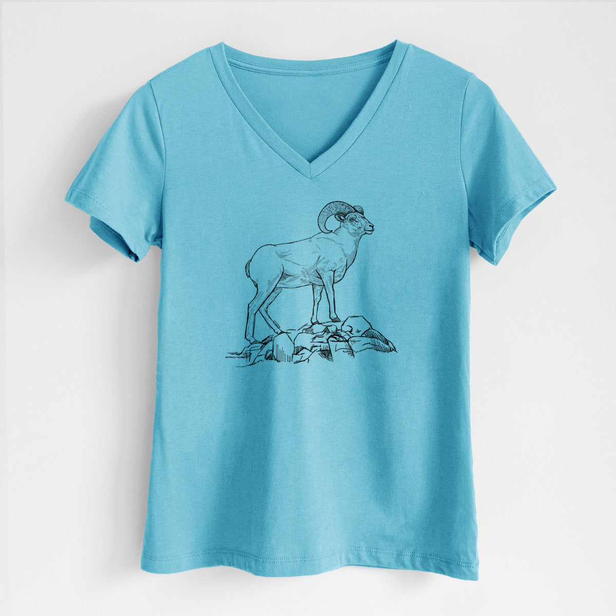 Turquoise women's relaxed fit cotton V-neck t-shirt laid flat, printed with a black ink illustration of a bighorn ram with curled horns standing on rocks.