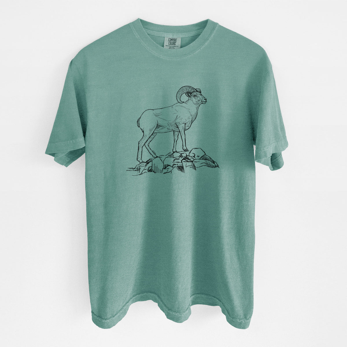 Reef green Comfort Colors t-shirt laid flat, printed with a black ink illustration of a bighorn ram with curled horns standing on rocks.