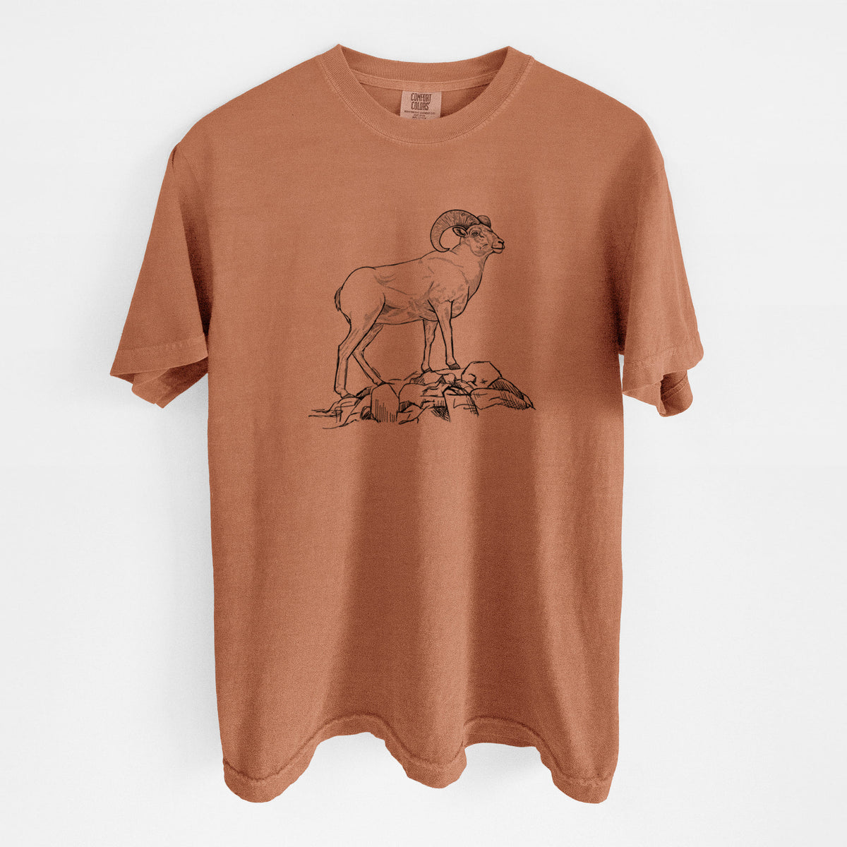Yam burnt orange Comfort Colors t-shirt laid flat, printed with a black ink illustration of a bighorn ram with curled horns standing on rocks.