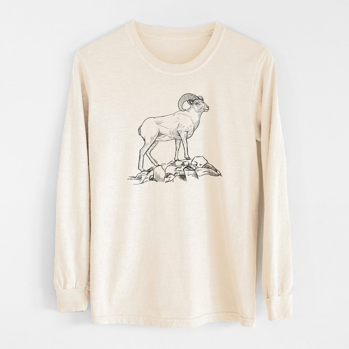 Ivory Comfort Colors long sleeve shirt laid flat, printed with a black ink illustration of a bighorn ram with curled horns standing on rocks.