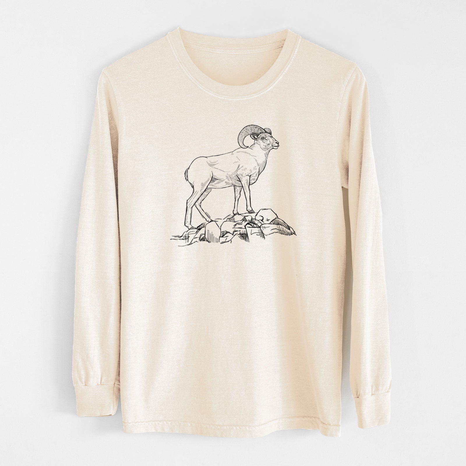 Ivory Comfort Colors long sleeve shirt laid flat, printed with a black ink illustration of a bighorn ram with curled horns standing on rocks.