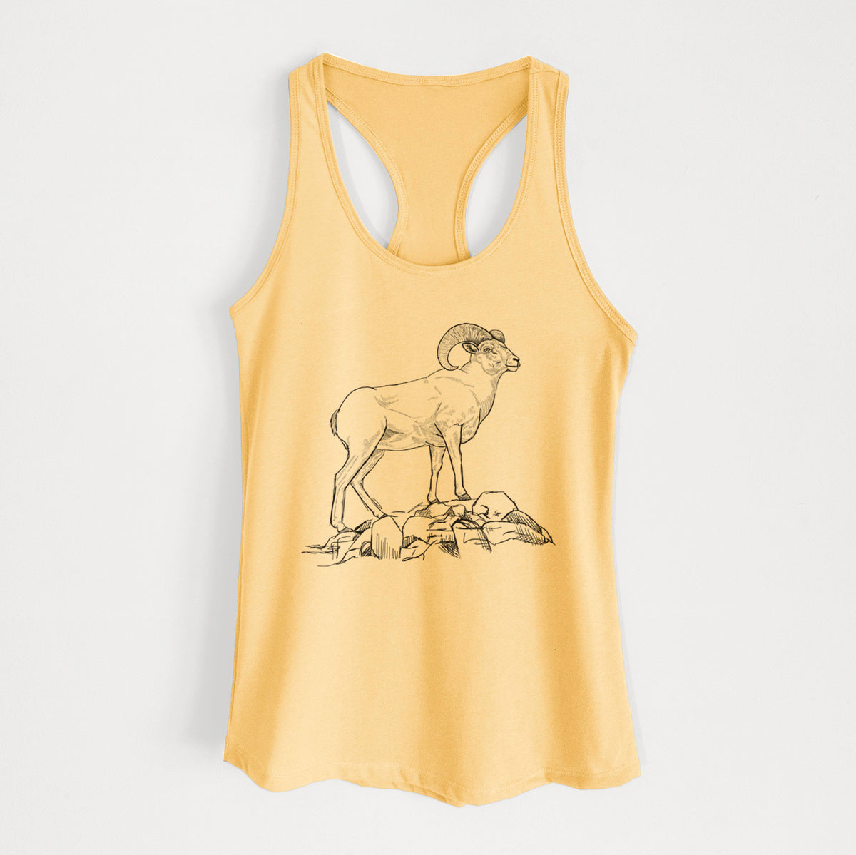 Banana cream women's racerback tank top laid flat, printed with a black ink illustration of a bighorn ram with curled horns standing on rocks.