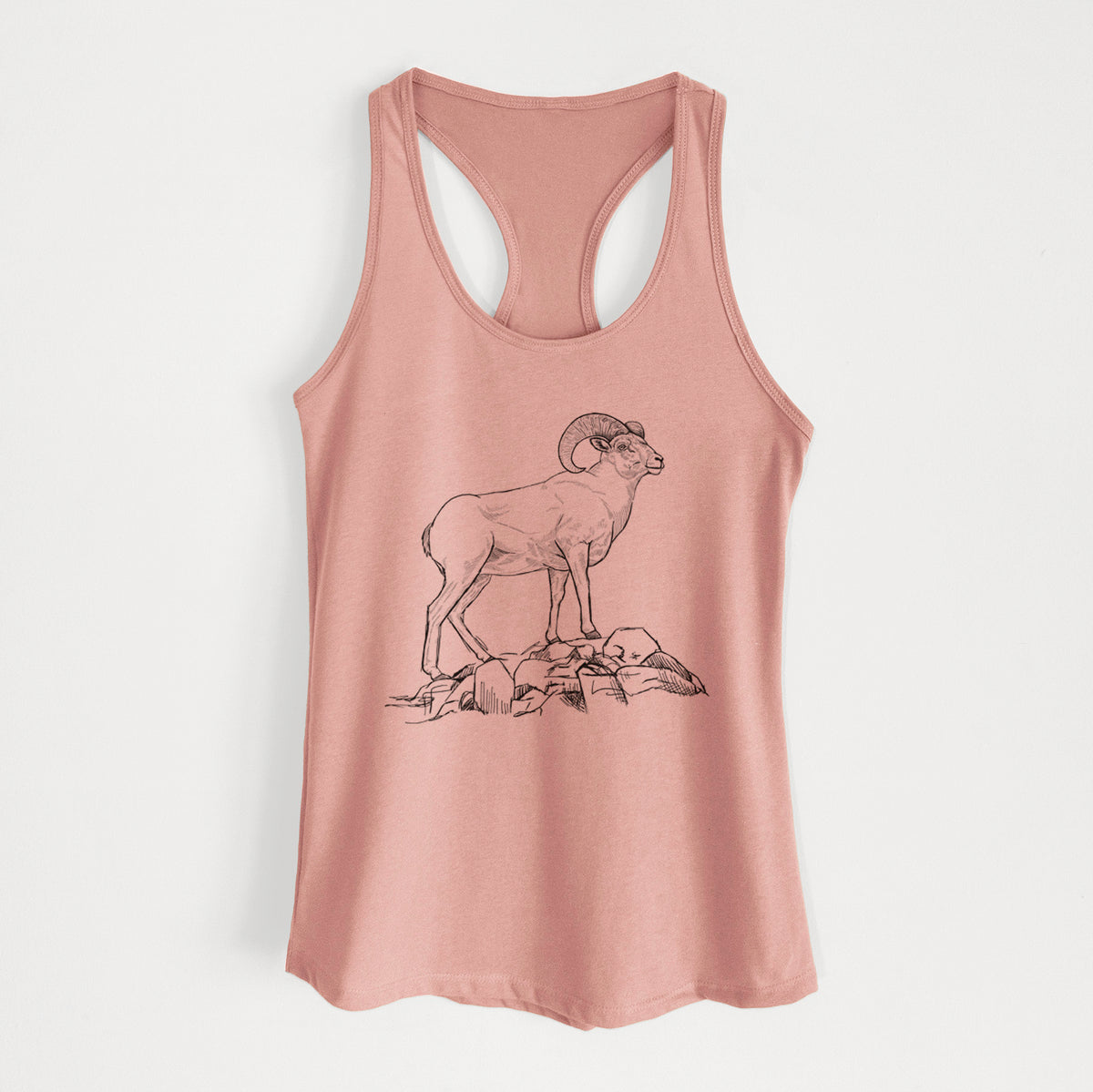 Desert pink women's racerback tank top laid flat, printed with a black ink illustration of a bighorn ram with curled horns standing on rocks.