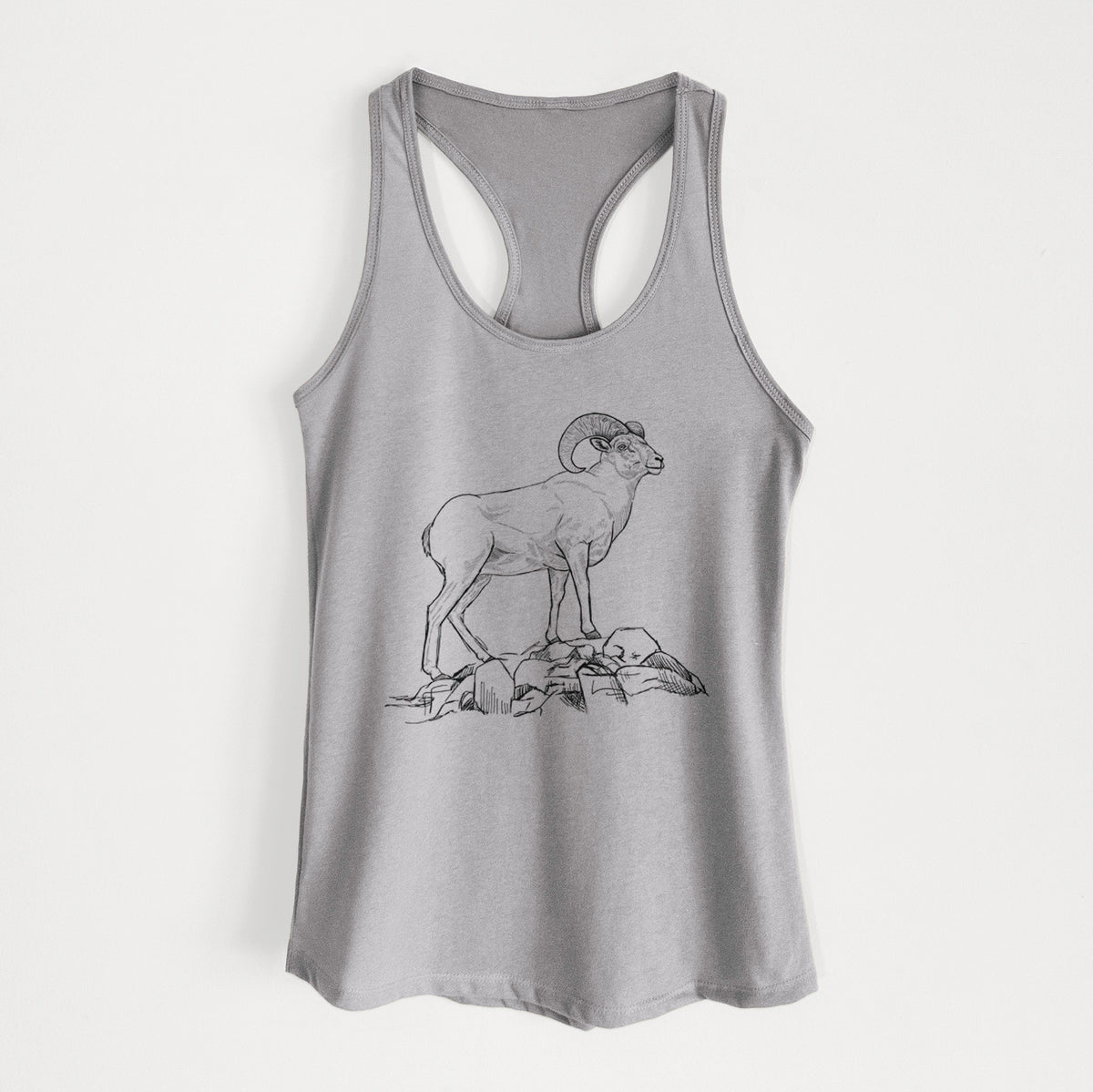 Heather grey women's racerback tank top laid flat, printed with a black ink illustration of a bighorn ram with curled horns standing on rocks.