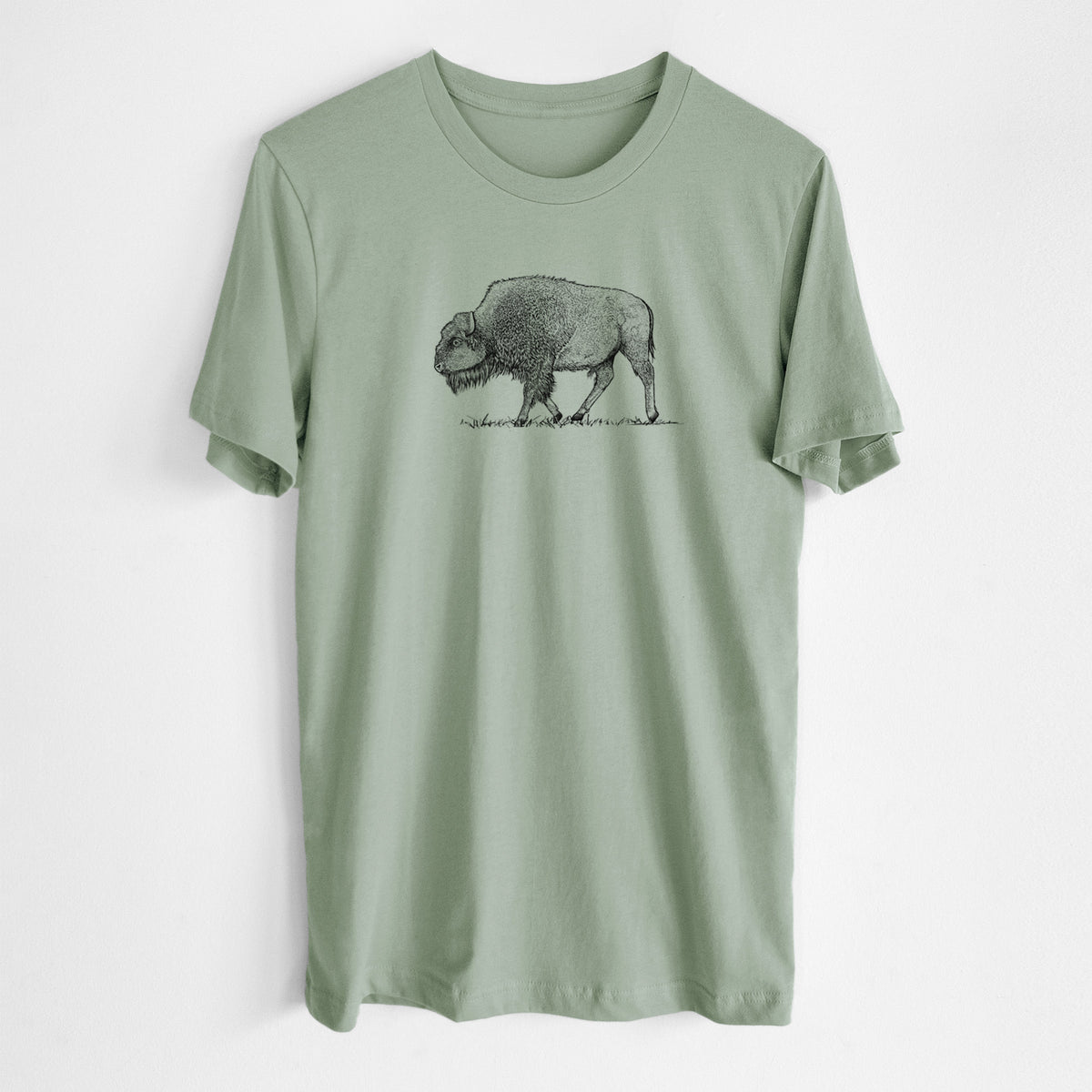 Sage green lightweight cotton t-shirt laid flat, printed with a detailed black ink illustration of an American bison walking through grass.