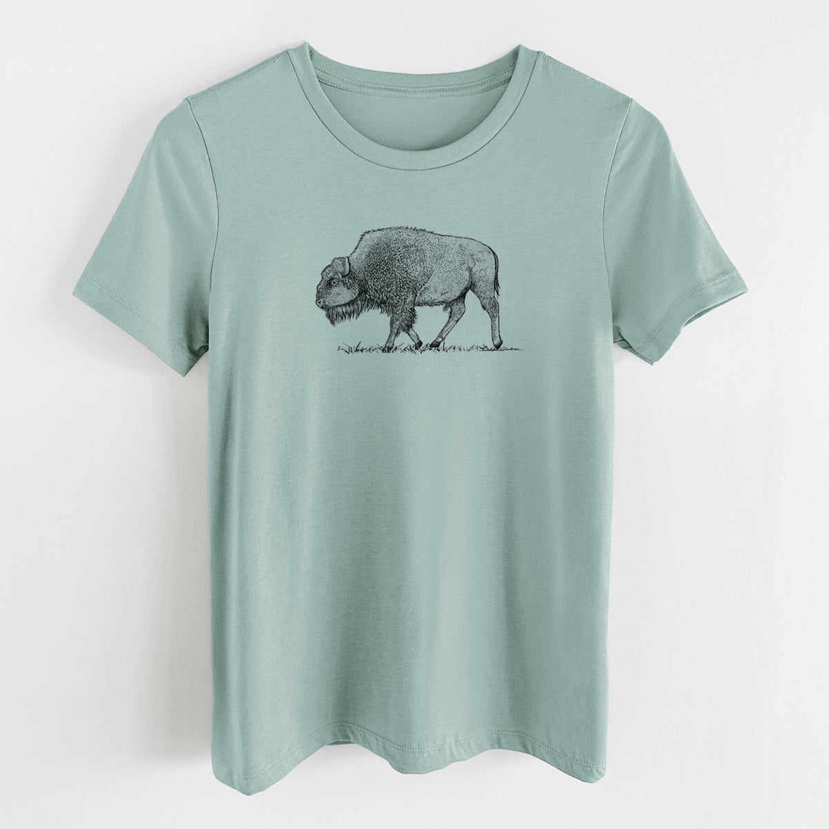 Dusty blue women's relaxed fit cotton t-shirt laid flat, printed with a detailed black ink illustration of an American bison walking through grass.