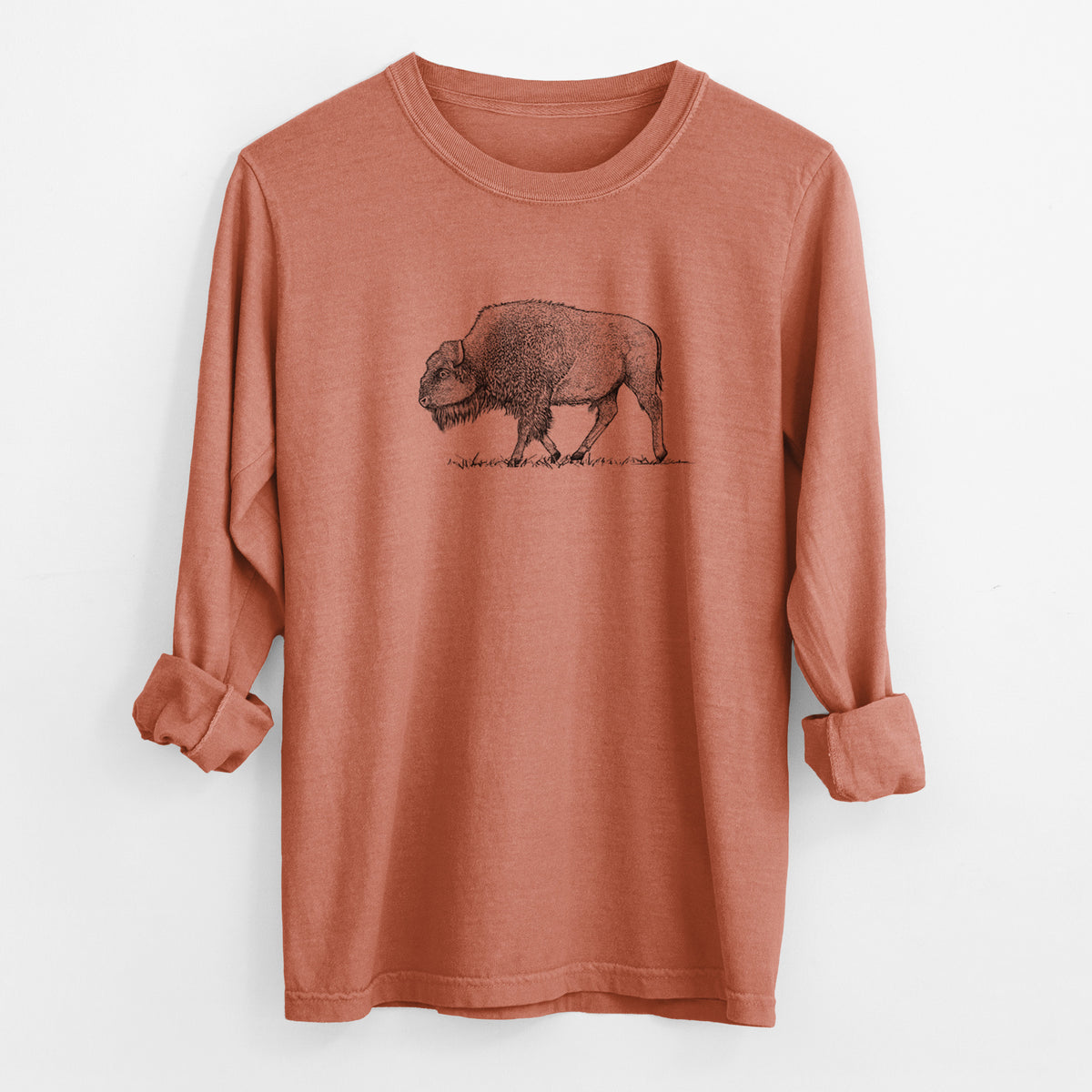 Yam burnt orange Comfort Colors long sleeve shirt laid flat with the cuffs rolled, printed with a detailed black ink illustration of an American bison walking through grass.
