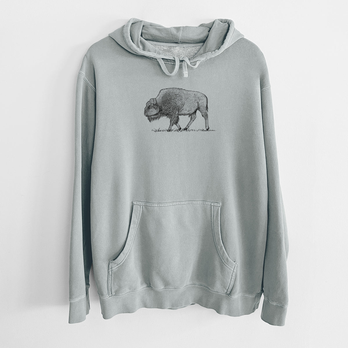 Sage green pigment dyed hoodie laid flat, printed with a detailed black ink illustration of an American bison walking through grass.