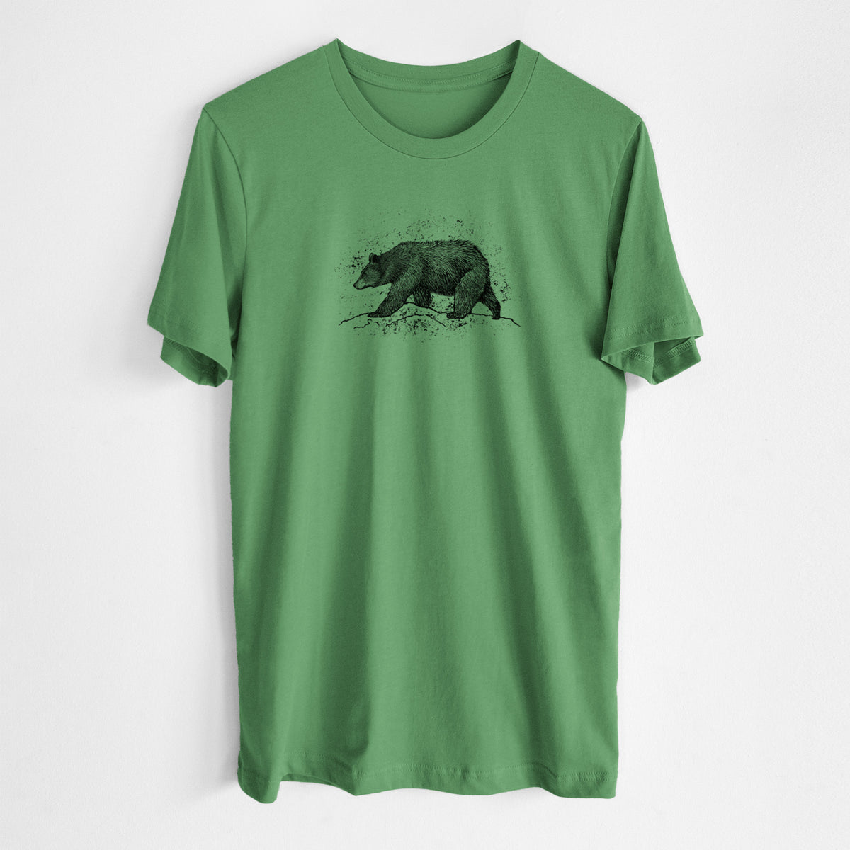 Leaf green lightweight cotton t-shirt laid flat, printed with a detailed black ink sketch of a black bear walking across rocky ground.