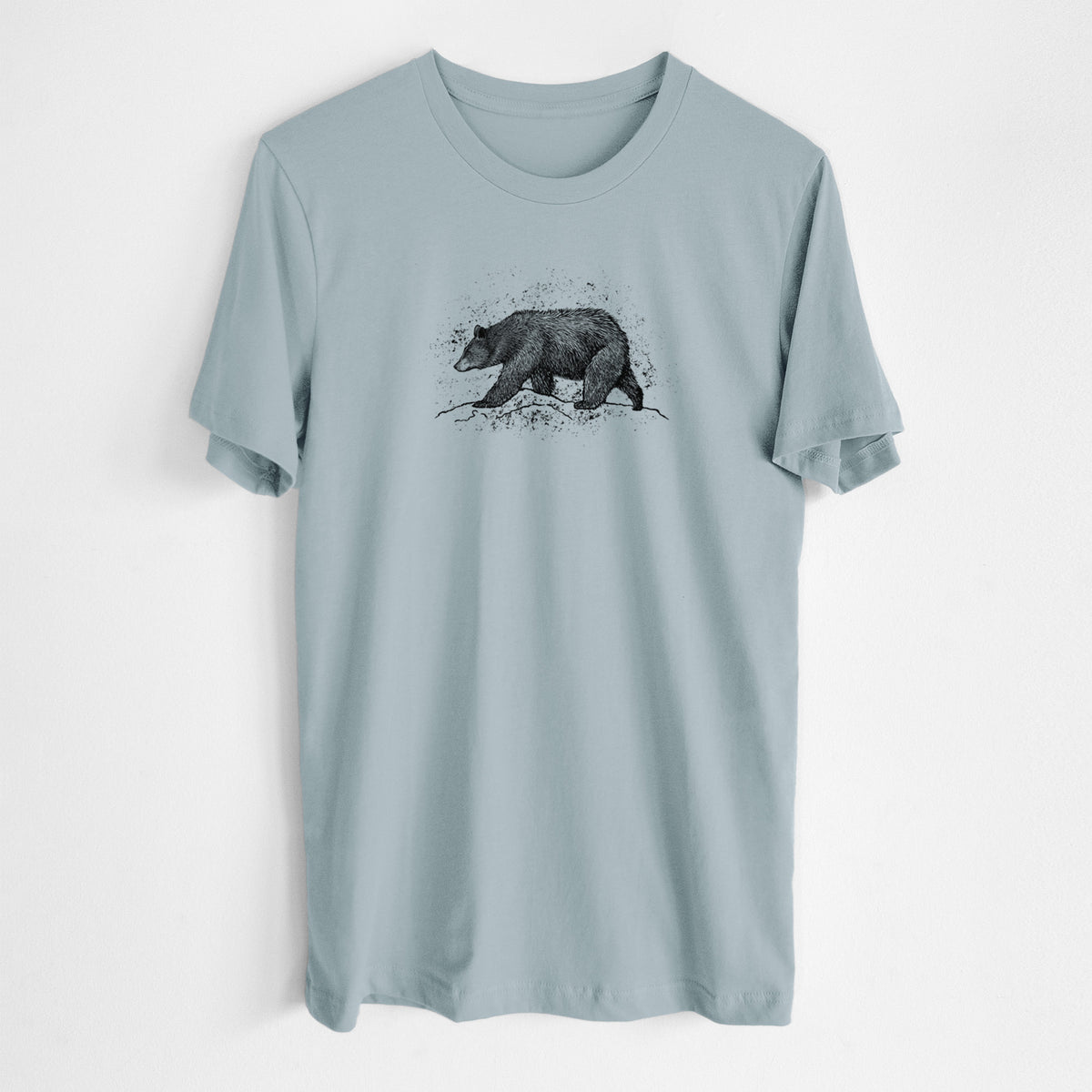 Vintage denim lightweight cotton t-shirt laid flat, printed with a detailed black ink sketch of a black bear walking across rocky ground.