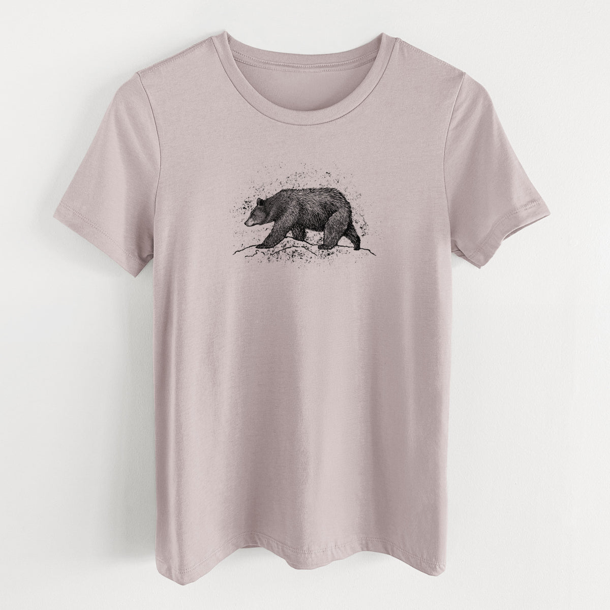 Pink gravel women's relaxed fit cotton t-shirt laid flat, printed with a detailed black ink sketch of a black bear walking across rocky ground.